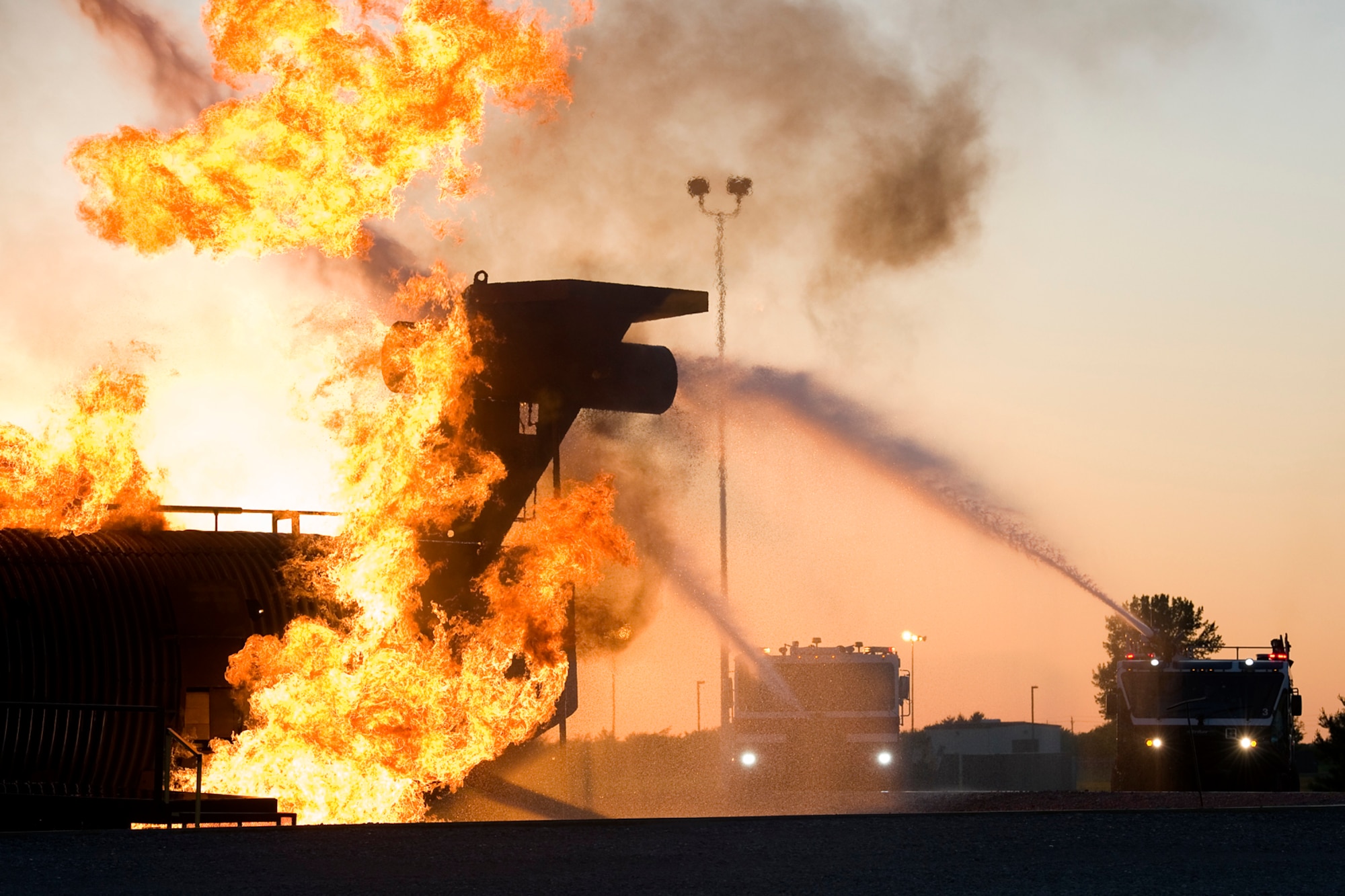 Grissom firefighters, operating two fire trucks, extinguish flames on a mock airframe during a night-time training exercise at Grissom Air Reserve Base, Ind., May 21, 2015. The fire department is one of several organizations at Grissom that work and train after dark and around the clock to ensure personnel and property are kept safe. (U.S. Air Force photo/Tech. Sgt. Benjamin Mota)