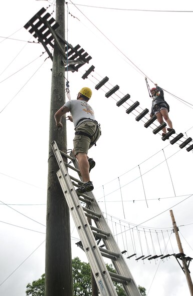 Senior Airman Michael Disieno, 319th Communications Squadron radio technician, climbs to the top of the 24-foot-high ropes course at Park River Bible Camp in Park River, N.D., June 22, 2015. The ropes course and climbing tower were a part of a resiliency day provided by the Grand Forks Air Force Base chapel team. (U.S. Air Force photo by Airman 1st Class Bonnie Grantham/released) 