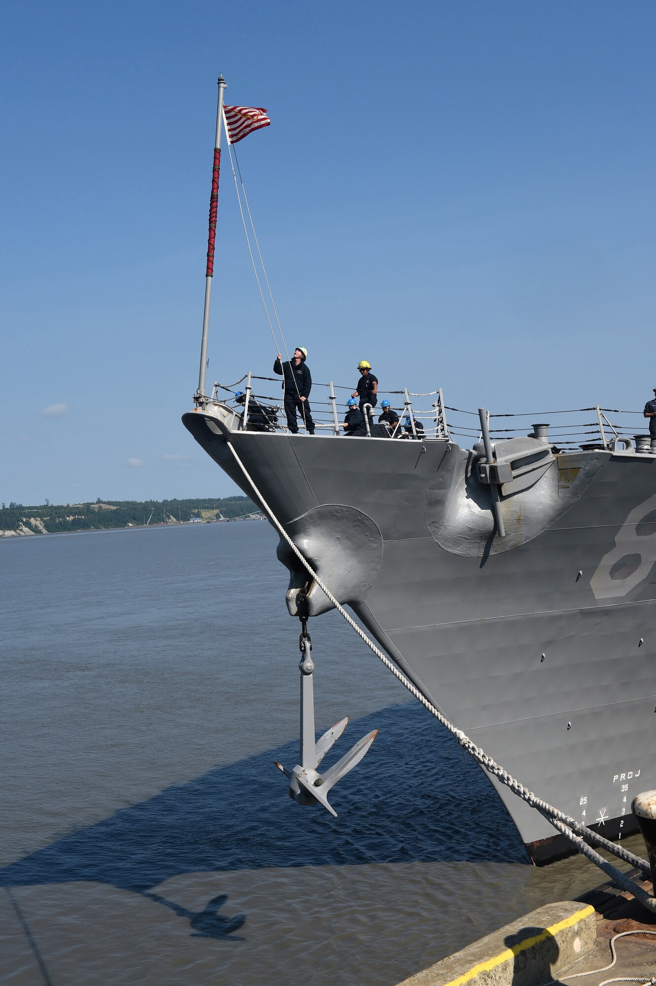 A crew member of the USS Shoup (DDG 86) raises the ship’s first Navy jack as it prepares to moor at the Port of Anchorage, Alaska, June 24, 2015. The Shoup is one of three U.S. Navy destroyers participating in Exercise Northern Edge out of the Gulf of Alaska. Thousands of service members from all the branch services including active duty, Reserve and National Guard units participated. (U.S. Navy photo/Chief Mass Communication Specialist Larry Foos)