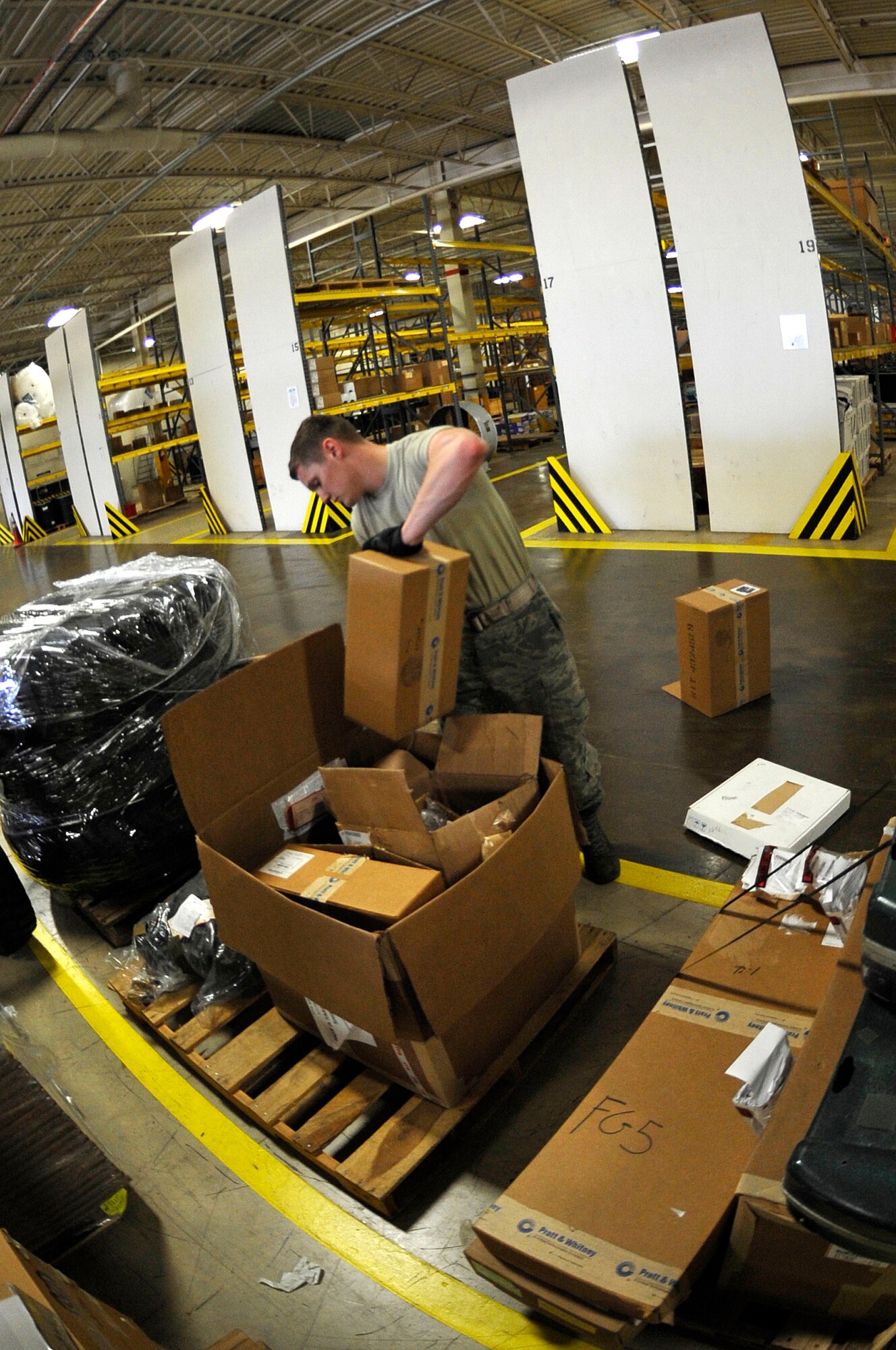 U.S. Air Force Airman 1st Class Tyler Stork, 633rd Logistics Readiness Squadron Traffic Management Operations inbound and receiving technician, packs a box designated for destruction at Langley Air Force Base, Va., June 24, 2015. Products determined unserviceable or inoperable are packed tightly and transported to a destruction site in Norfolk, Va. (U.S. Air Force photo by Senior Airman Breonna Veal)
