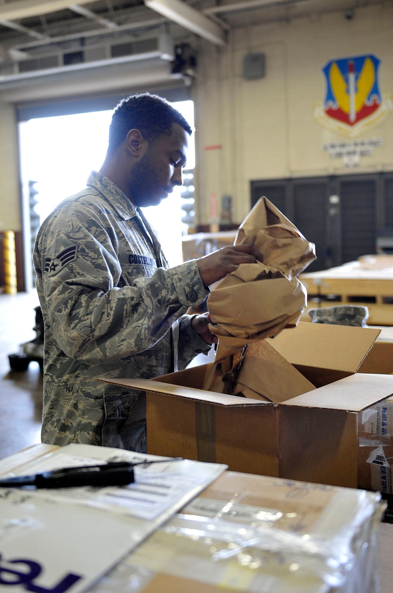 U.S. Air Force Senior Airman Anthony Castello, 633rd Logistics Readiness Squadron Traffic Management Operations inbound and receiving technician, inspects the contents a box at Langley Air Force Base, Va., June 24, 2015. Every package that travels through Langley must be examined and processed before delivery to the customer. (U.S. Air Force photo by Senior Airman Breonna Veal)