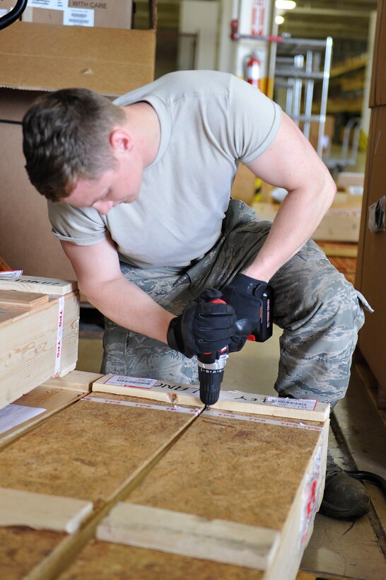 U.S. Air Force Airman 1st Class Tyler Stork, 633rd Logistics Readiness Squadron Traffic Management Operations inbound and receiving technician, opens a crate at Langley Air Force Base, Va., June 24, 2015. Inbounding and receiving technicians ensure packages on base arrive at the appropriate units and shops. (U.S. Air Force photo by Senior Airman Breonna Veal)  