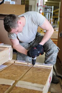 U.S. Air Force Airman 1st Class Tyler Stork, 633rd Logistics Readiness Squadron Traffic Management Operations inbound and receiving technician, opens a crate at Langley Air Force Base, Va., June 24, 2015. Inbounding and receiving technicians ensure packages on base arrive at the appropriate units and shops. (U.S. Air Force photo by Senior Airman Breonna Veal)  