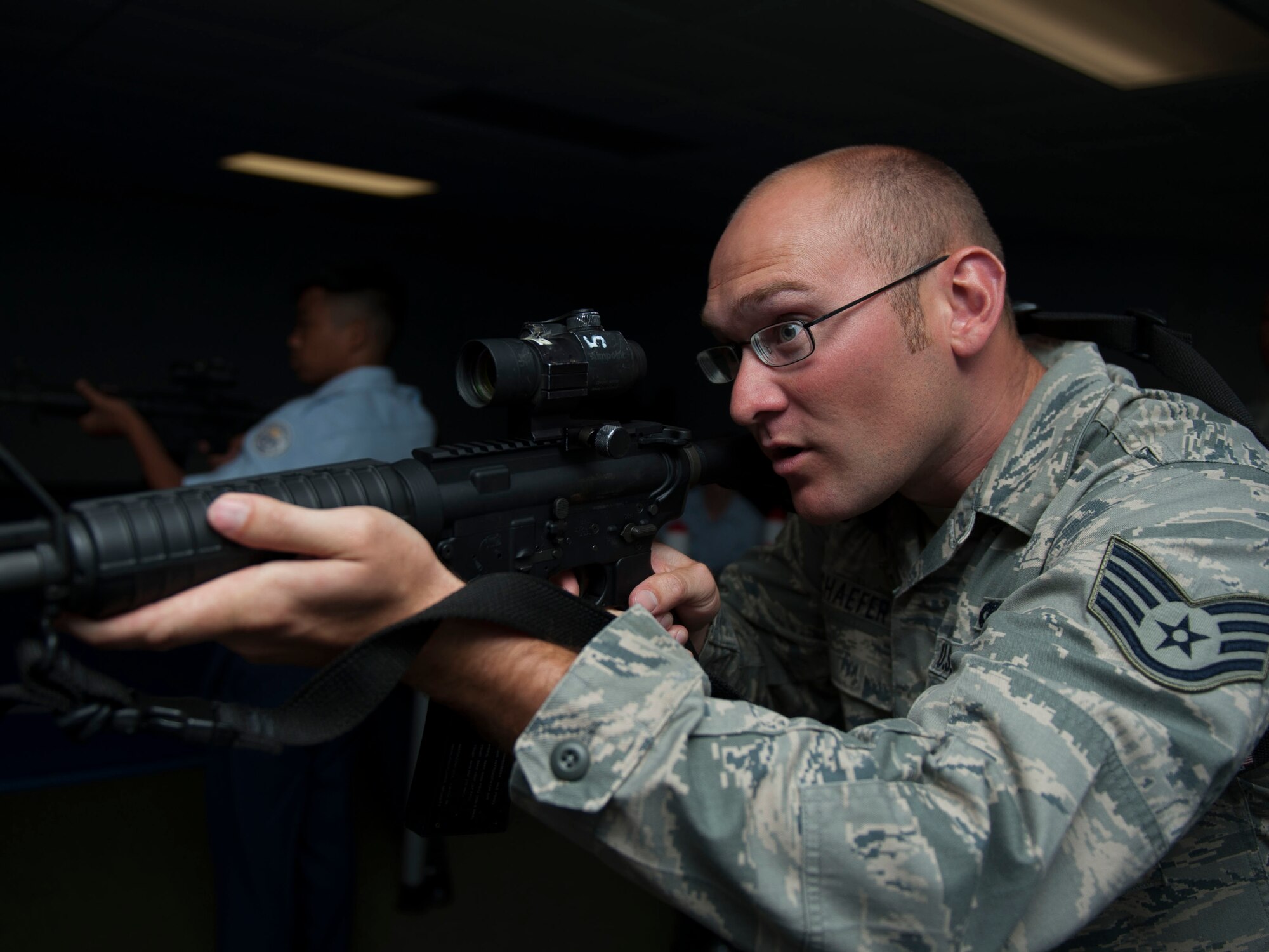U.S. Air Force Staff Sgt. Justin Schaefer, 633rd Security Forces Squadron trainer, participates in a virtual range simulator shooting drill with Darryll Ducusin, Menchville High School Junior ROTC cadet at Langley Air Force Base, Va., June 23, 2015. The virtual range simulator allowed cadets to execute the training involved engaging suspects, handling situations and executing proper safety techniques. (U.S Air Force photo by Staff Sgt. John D. Strong II/ Released)