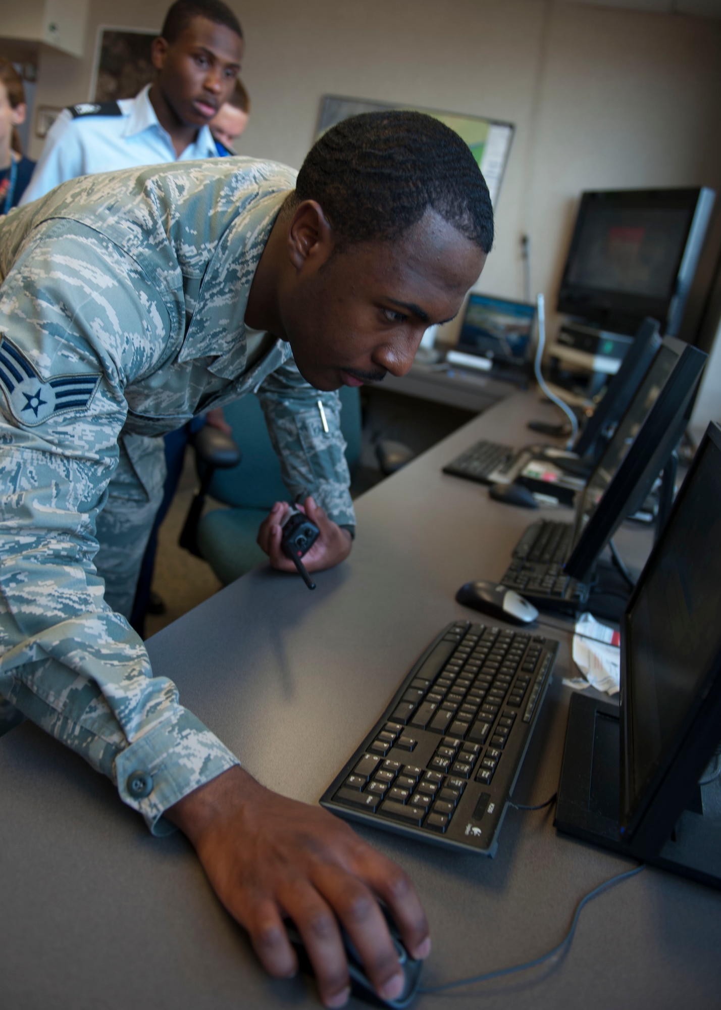 U.S. Air Force Senior Airman Brandon Burns, 1st Operations Support Squadron airfield management shift lead, demonstrates the capabilities of the federal aviation administration tracker system to Junior ROTC cadets during Shadow Day at Langley Air Force Base, Va., June 23, 2015. Airfield Management specialists ensure runways are clear of foreign objects and lighting systems function properly, in addition to responding to ground emergencies and communicating hazards to pilots. (U.S Air Force photo by Staff Sgt. John D. Strong II/ Released)