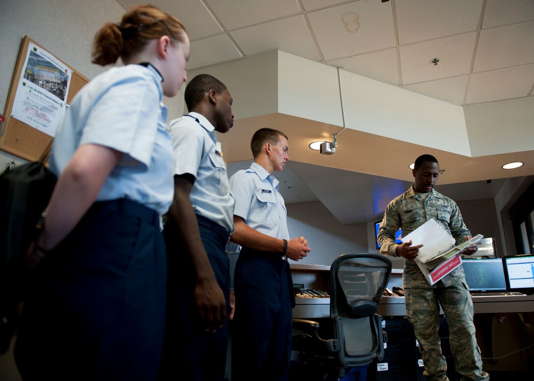 U.S. Air Force Senior Airman Brandon Burns, 1st Operations Support Squadron airfield management shift lead, explains proper flight plan procedures to Junior ROTC cadets during Shadow Day at Langley Air Force Base, Va., June 23, 2015. Burns manages airfield operations to ensure a safe, efficient and effective airfield environment by inspecting runways, taxiways, parking aprons, pavements, arresting systems, signs, lighting and airfield clearance areas. (U.S Air Force photo by Staff Sgt. John D. Strong II/ Released)