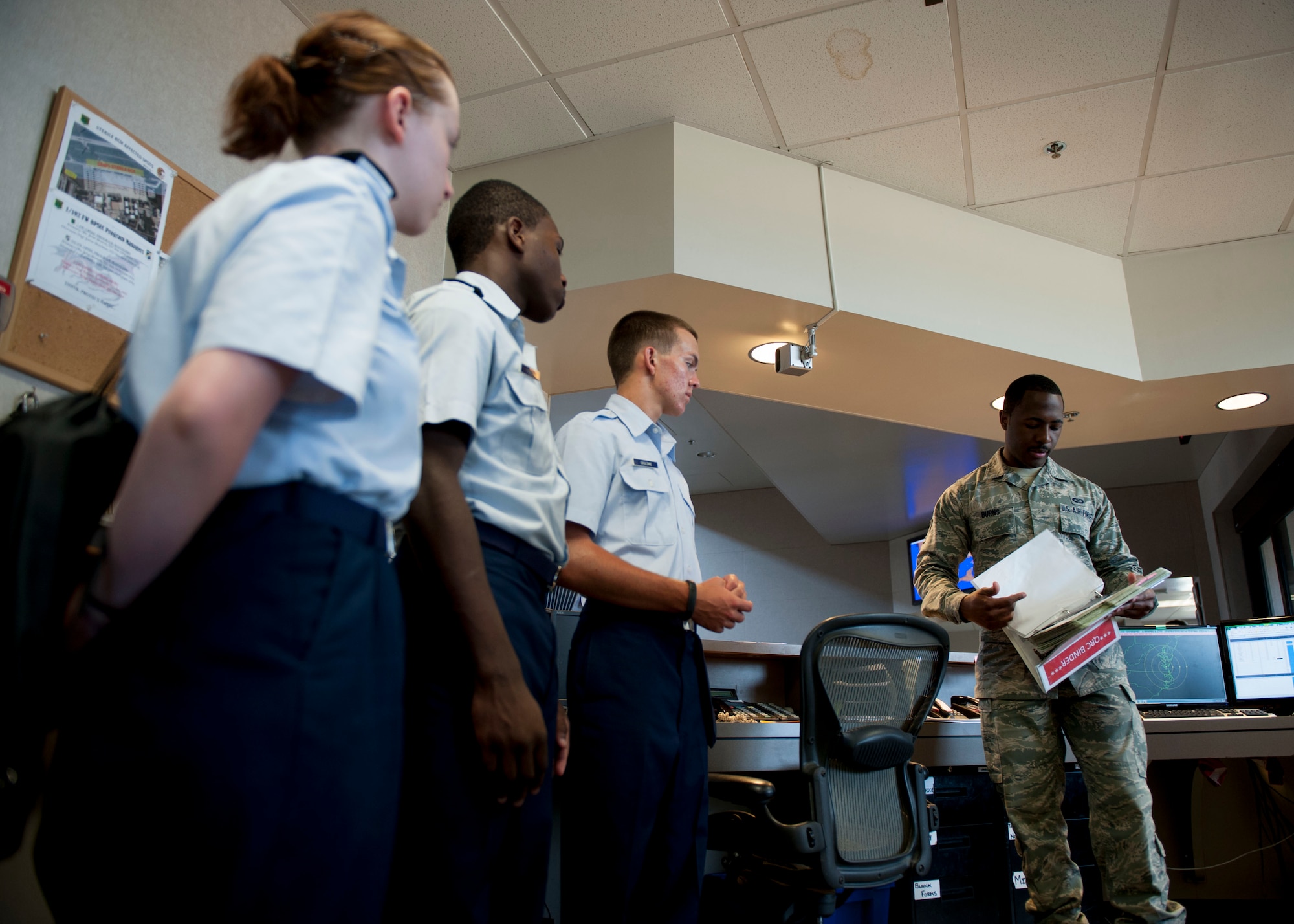 U.S. Air Force Senior Airman Brandon Burns, 1st Operations Support Squadron airfield management shift lead, explains proper flight plan procedures to Junior ROTC cadets during Shadow Day at Langley Air Force Base, Va., June 23, 2015. Burns manages airfield operations to ensure a safe, efficient and effective airfield environment by inspecting runways, taxiways, parking aprons, pavements, arresting systems, signs, lighting and airfield clearance areas. (U.S Air Force photo by Staff Sgt. John D. Strong II/ Released)