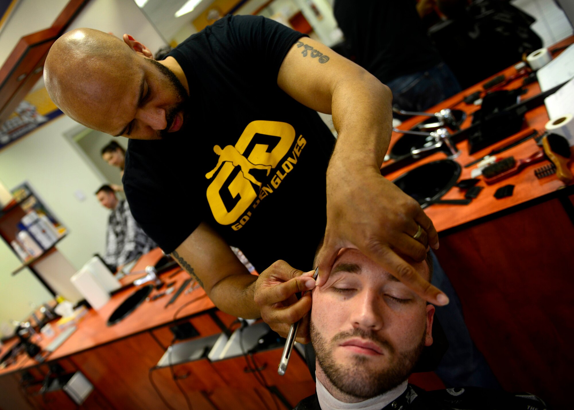 Eric Morris Santiago, local barber, lines up a customer’s hairline, June 25, 2015, at Aviano Air Base, Italy. Santiago served six years in the U.S. Air Force and as a logistics readiness supply Airmen and worked as a contractor for 10 years before deciding to become a barber. (U.S. Air Force photo by Senior Airman Areca T. Wilson/Released)