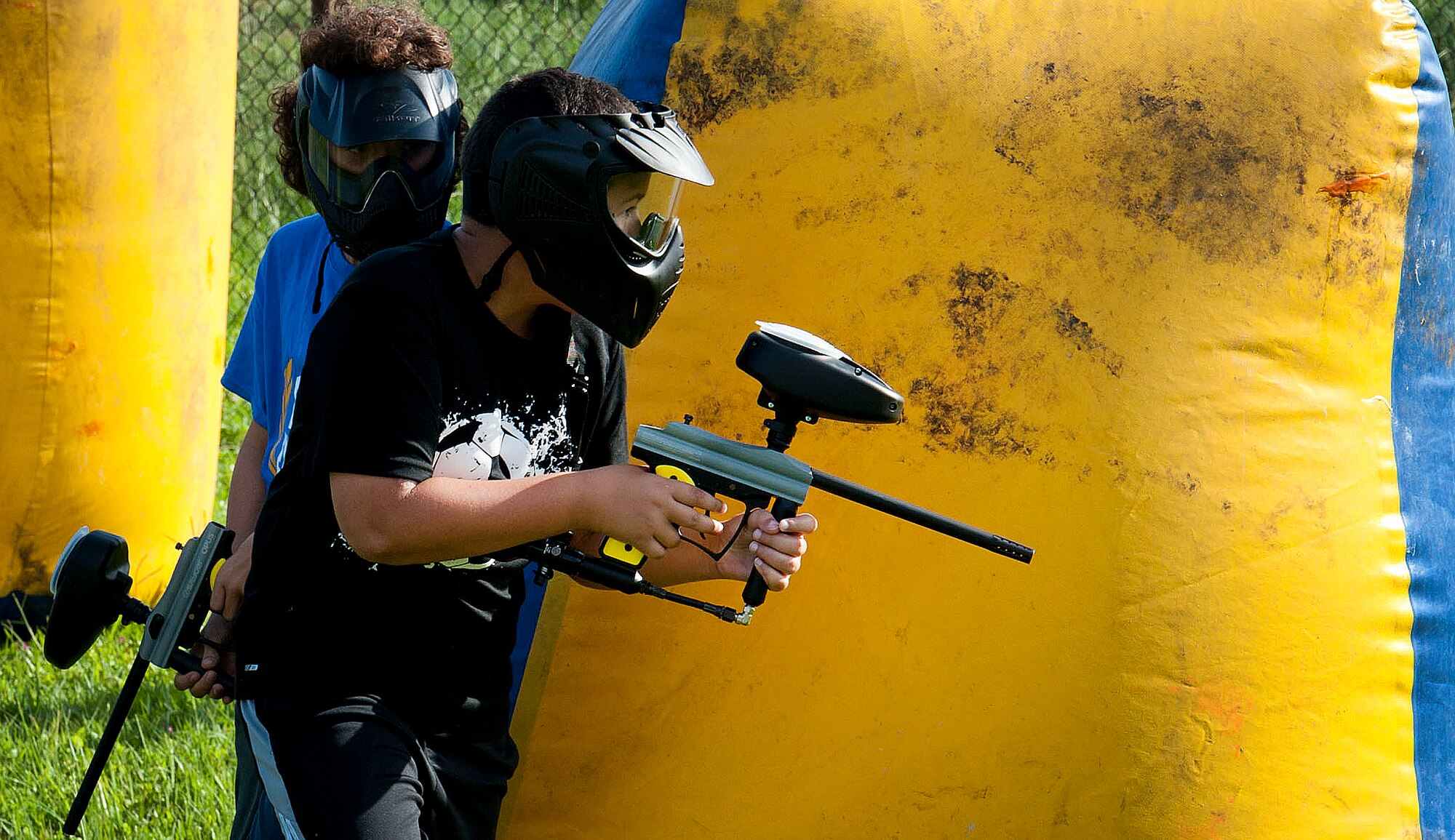 Children of Team MacDill wait to shoot their opponent during a paintball game June 23, 2015, at MacDill Air Force Base, Fla. Children ages nine and older were eligible to participate in a week-long Paintball Camp offered by the Youth Center from June 22-26. (U.S. Air Force photo by Senior Airman Jenay Randolph/Released)