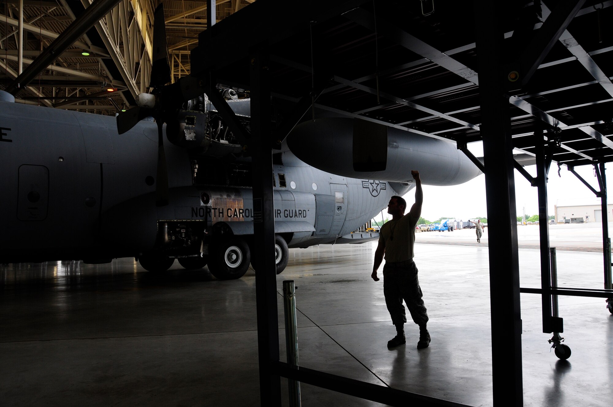 U.S. Air Force Staff Sgt. Jason Hudson, crew chief for the 145th Maintenance Squadron, walks the wing during the first tow of a C-130 Hercules aircraft being positioned with the new Isochronal Inspection (ISO) Aircraft Maintenance Platform at the North Carolina Air National Guard base, Charlotte Douglas International Airport, June 2, 2015. These stands are part of an Air Force-wide mission to replace aircraft maintenance stands for all C-130 aircraft. (U.S. Air National Guard photo by Master Sgt. Patricia F. Moran, 145th Public Affairs/Released)