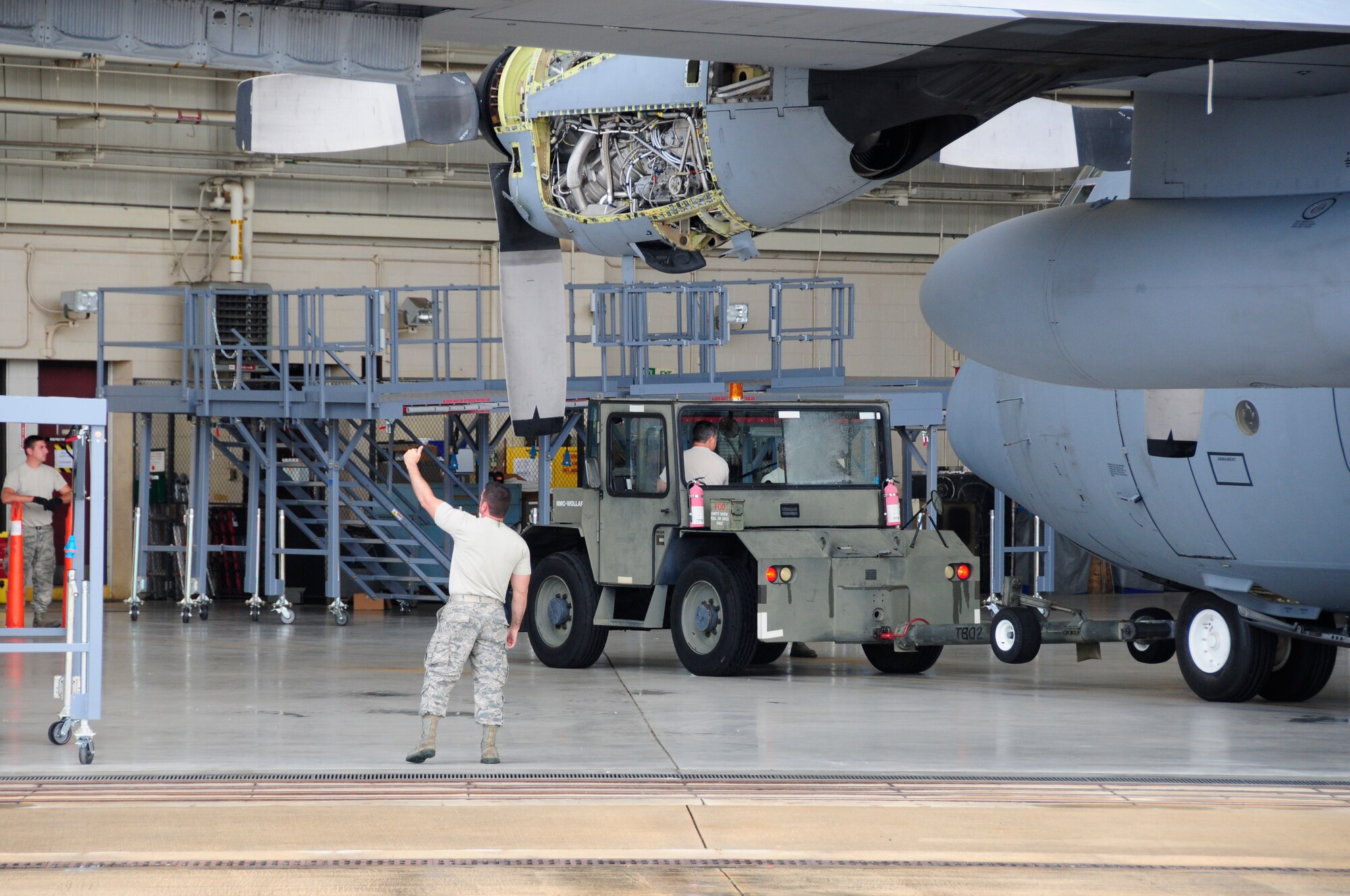 U.S. Air Force Staff Sgt. Jason Hudson, crew chief for the 145th Maintenance Squadron, signals all clear as the first 145th Airlift Wing, C-130 Hercules aircraft is towed into position with the new Isochronal Inspection (ISO) Aircraft Maintenance Platforms at the North Carolina Air National Guard base, Charlotte Douglas International Airport, June 2, 2015. These new ISO stands are part of an Air Force-wide mission to replace aircraft maintenance stands for all C-130 aircraft. (U.S. Air National Guard photo by Master Sgt. Patricia F. Moran, 145th Public Affairs/Released)