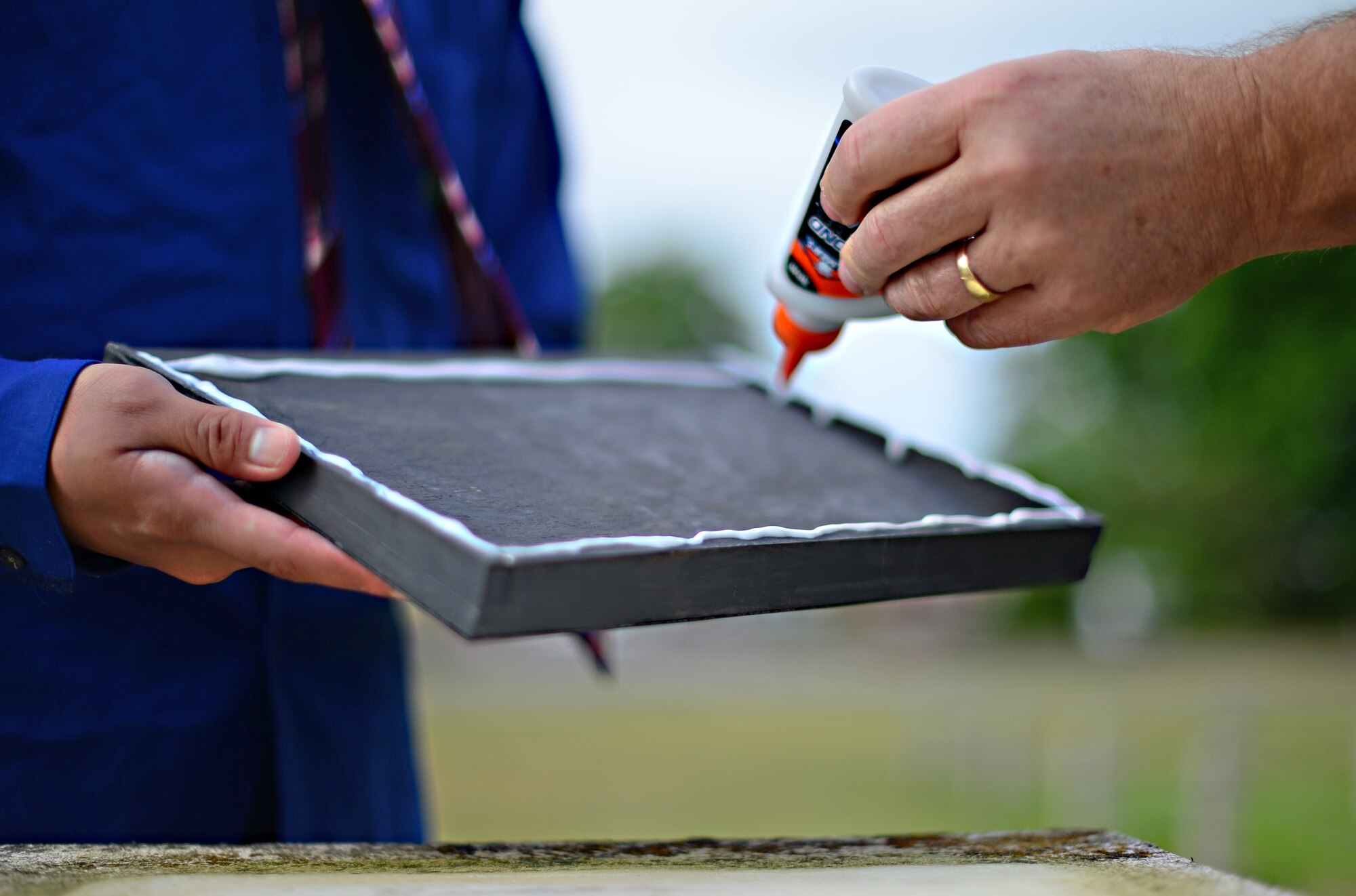 Josh Kelley, a former Air Force Junior ROTC member, and his father Terry, apply glue to the surface of a memorial plaque dedicated to the 495th Tactical Fighter Squadron, a deactivated fighter squadron, at Royal Air Force Lakenheath, England, June 19, 2015. Activated in 1977, the squadron functioned as a replacement training unit for the Liberty Wing’s 492nd, 493rd and 494th Fighter Squadrons that are active today. (U.S. Air Force photo by Senior Airman Erin O’Shea/Released)