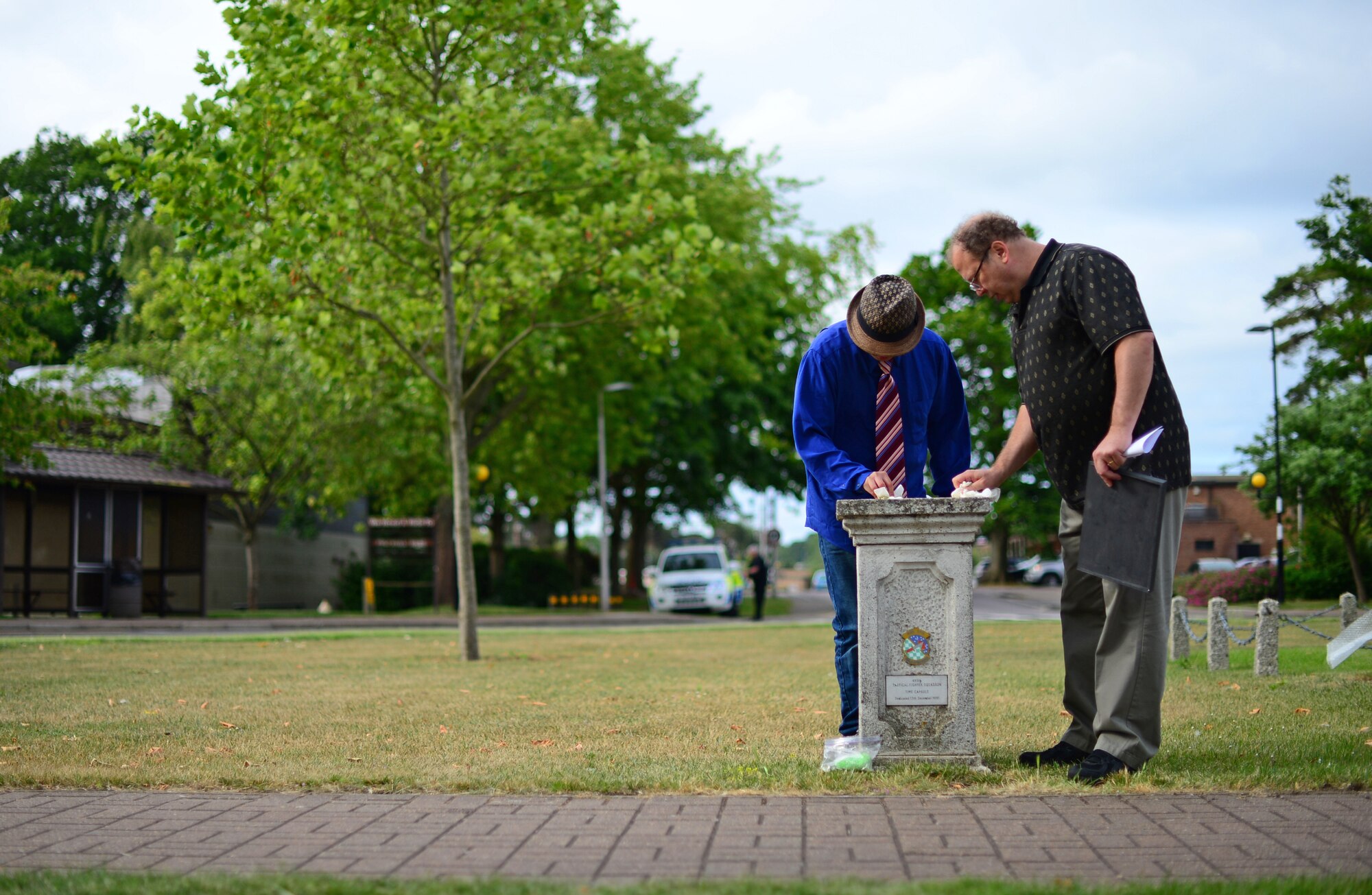Josh Kelley, a former Air Force Junior ROTC member, and his father Terry, clean the surface of a memorial plaque dedicated to the 495th Tactical Fighter Squadron, a deactivated fighter squadron, at Royal Air Force Lakenheath, England, June 19, 2015. Josh replaced the old plaque with a more legible new one, donated by the base arts and crafts center, as a way to remember the fallen Airmen assigned to the 495th TFS. (U.S. Air Force photo by Senior Airman Erin O’Shea/Released) 