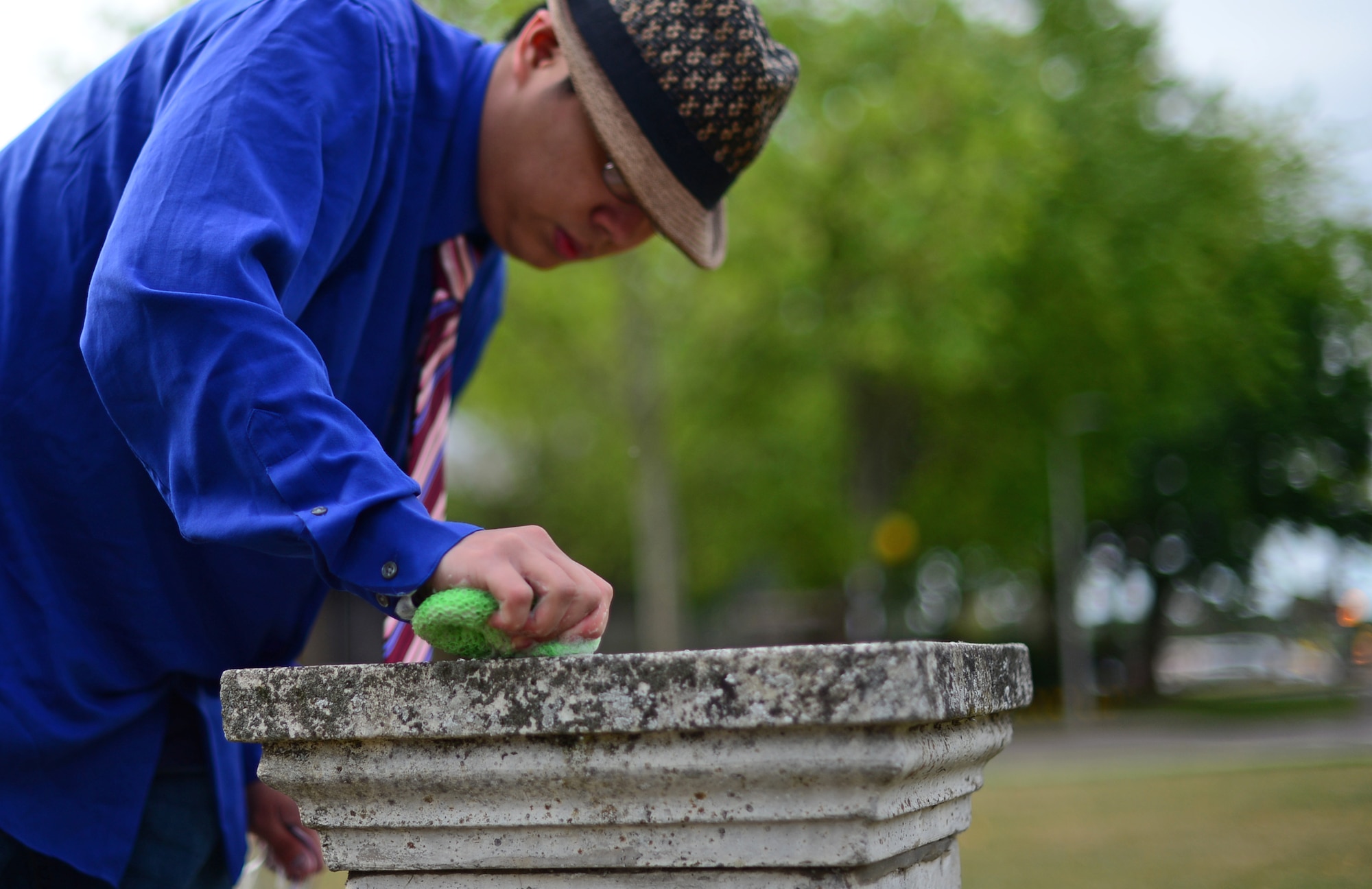 Josh Kelley, a former Air Force Junior ROTC member, cleans a memorial dedicated to the 495th Tactical Fighter Squadron, a deactivated fighter squadron, placed on Royal Air Force Lakenheath, England, June 19, 2015. Kelley replaced the previous plaque, placed in 1991, with a new plaque donated by the base arts and craft center. (U.S. Air Force photo by Senior Airman Erin O’Shea/Released)
