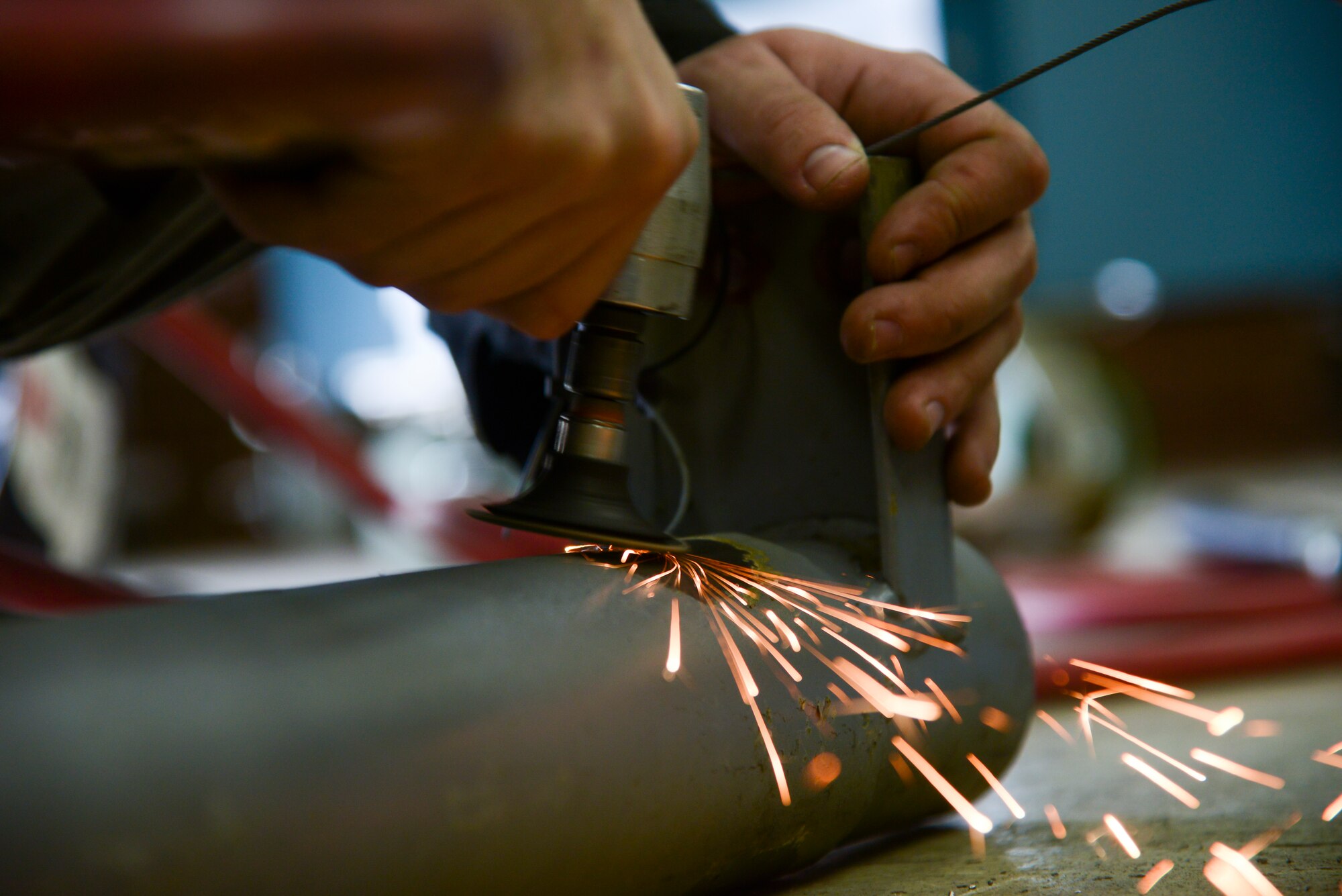 Airman 1st Class Curtis Doherty, 374th Maintenance Squadron aircraft metals technology journeyman, sands down part of a tow bar at the fabrication shop at Yokota Air Base, Japan, June 23, 2015. The shop often receives C-130 Hercules exhaust pipes to repair utilizing the technicians’ grinding and welding skills. (U.S. Air Force photo by Senior Airman David Owsianka/Released)
