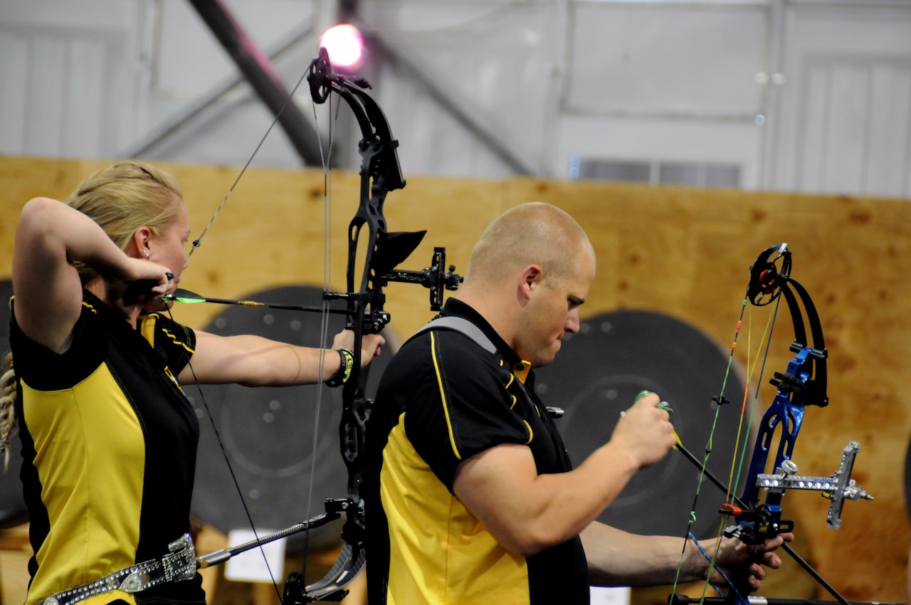 Army Reserve Spc. Chasity Kuczer and Army Reserve Sgt. Colten Harms shoot the compound bow during the archery competition at the 2015 DoD Warrior Games at Marine Corp Base Quantico, Va., June 22, 2015. Kuczer earned the gold medal and Harms earned the bronze medal. DoD photo by Shannon Collins
