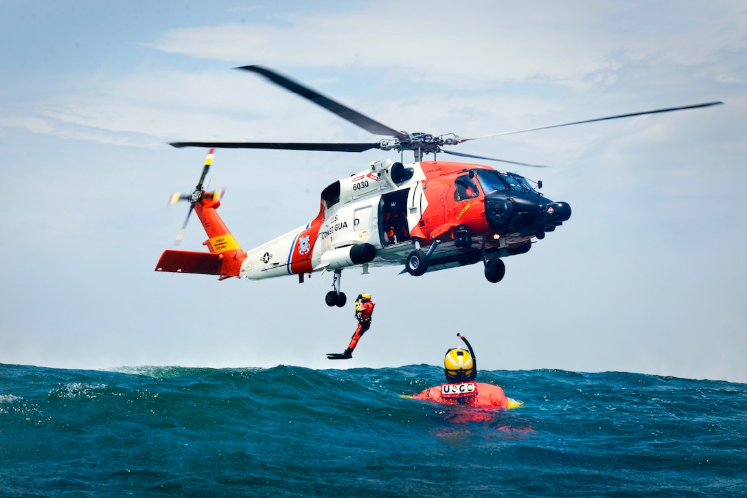 U S Coast Guardsmen Practice Hoisting Procedures With An MH Jayhawk Helicopter Off The Coast