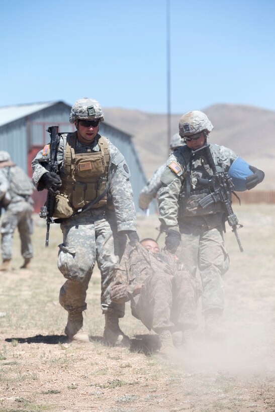 U.S. Army Spc. John Hahn, left, and Pfc. Andrew Lykins carry a casualty role player to a collection point during Exercise Khaan Quest 2015 at Five Hills Training Area in Tavantolgoi, Mongolia, June 25, 2015.