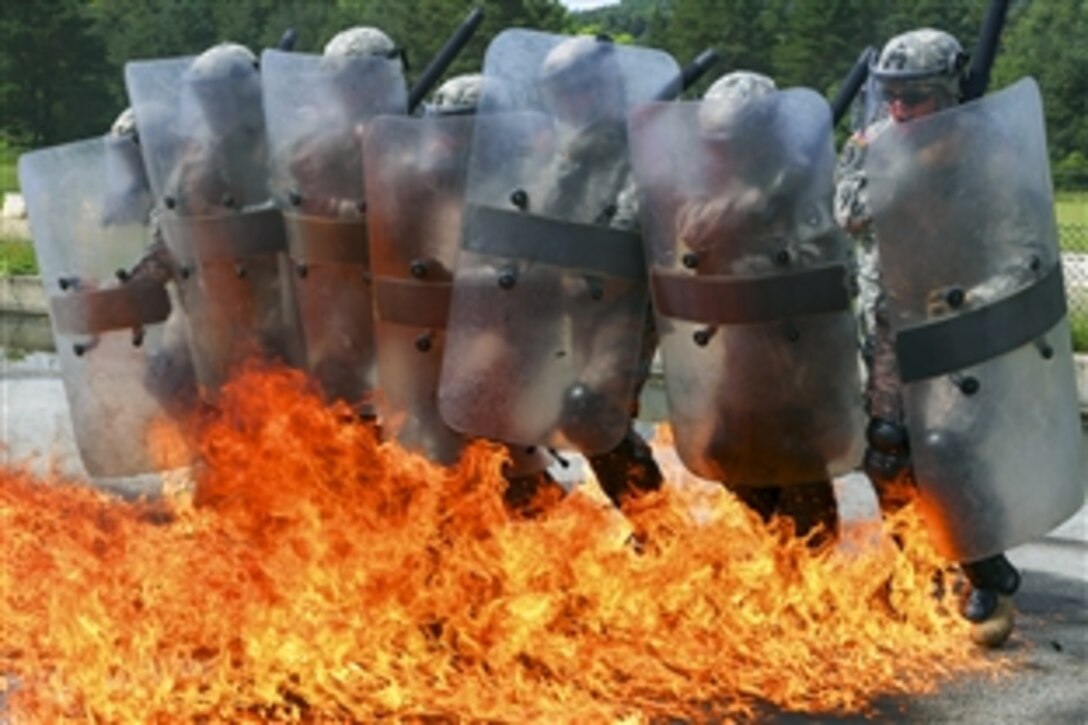 U.S. soldiers move through fire during fire phobia training during a Kosovo Force mission rehearsal exercise at the Joint Multinational Readiness Center in Hohenfels, Germany, June 16, 2015. The soldiers are assigned to the 1st Battalion, 252nd Armored Regiment.