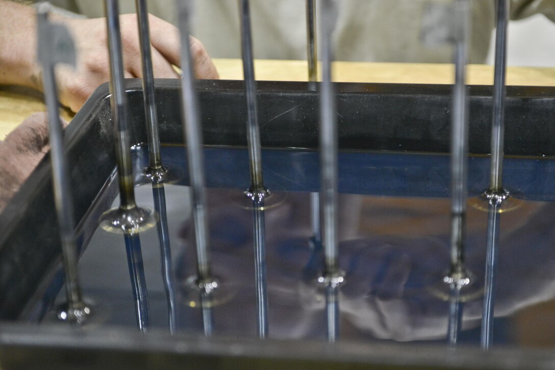 Senior Airman Brent Turner, 379th Expeditionary Logistics Readiness Squadron vehicle maintenance, soak the pistons of a passenger bus engine prior to cleaning and re-installing them June 24, 2015 Al Udeid Air Base, Qatar. Airman from the 379th Expeditionary Logistics Readiness Squadron vehicle maintenance shop service over 1,000 government owned vehicles that directly support the mission ranging from small sedans, buses, aircraft and structural support vehicles (U.S. Air Force photo/ Staff Sgt. Alexandre Montes)  