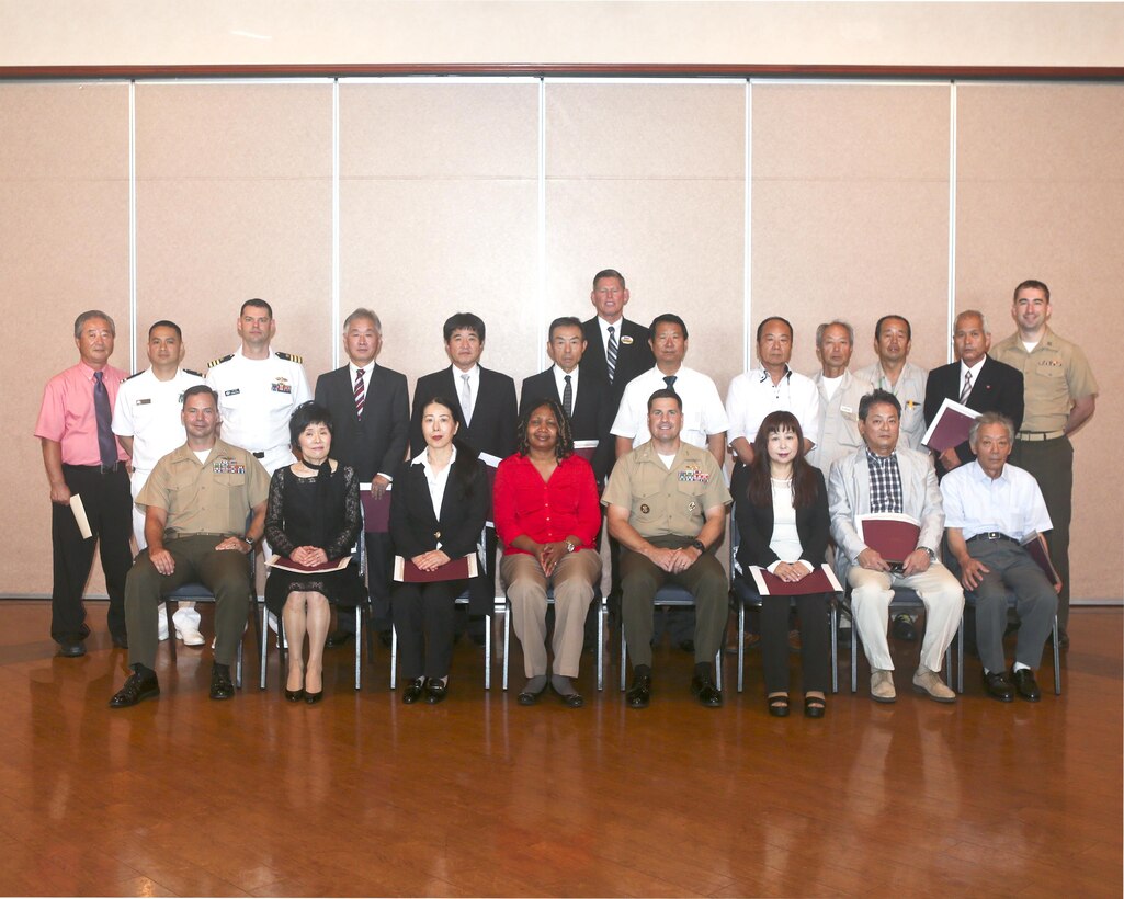 Department representatives, U.S. officials and retirees pose for a picture after the retirement ceremony at the Landing Zone inside Club Iwakuni aboard Marine Corps Air Station Iwakuni, Japan, June 25, 2014. This ceremony is held annually to honor all of the Japanese contractors retiring within the year and to show the station’s appreciation for their faithful service.
