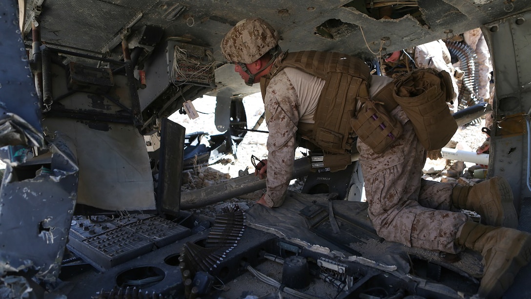 Marines with 1st Explosive Ordnance Disposal Company, 1st Marine Logistics Group, I Marine Expeditionary Force, search a downed UH-1 Huey helicopter for sensitive electronic components during a training exercise in Marine Corps Air Ground Combat Center Twentynine Palms, Calif., where they were tasked with sanitizing a wreckage site of any intelligence or ordnance an enemy force could use to their advantage, June 17, 2015. The Marines of 1st EOD Co. are preparing for an upcoming deployment with Special Purpose Marine Air Ground Task Force – Crisis Response – Central Command where they will participate in a fast reaction force role.