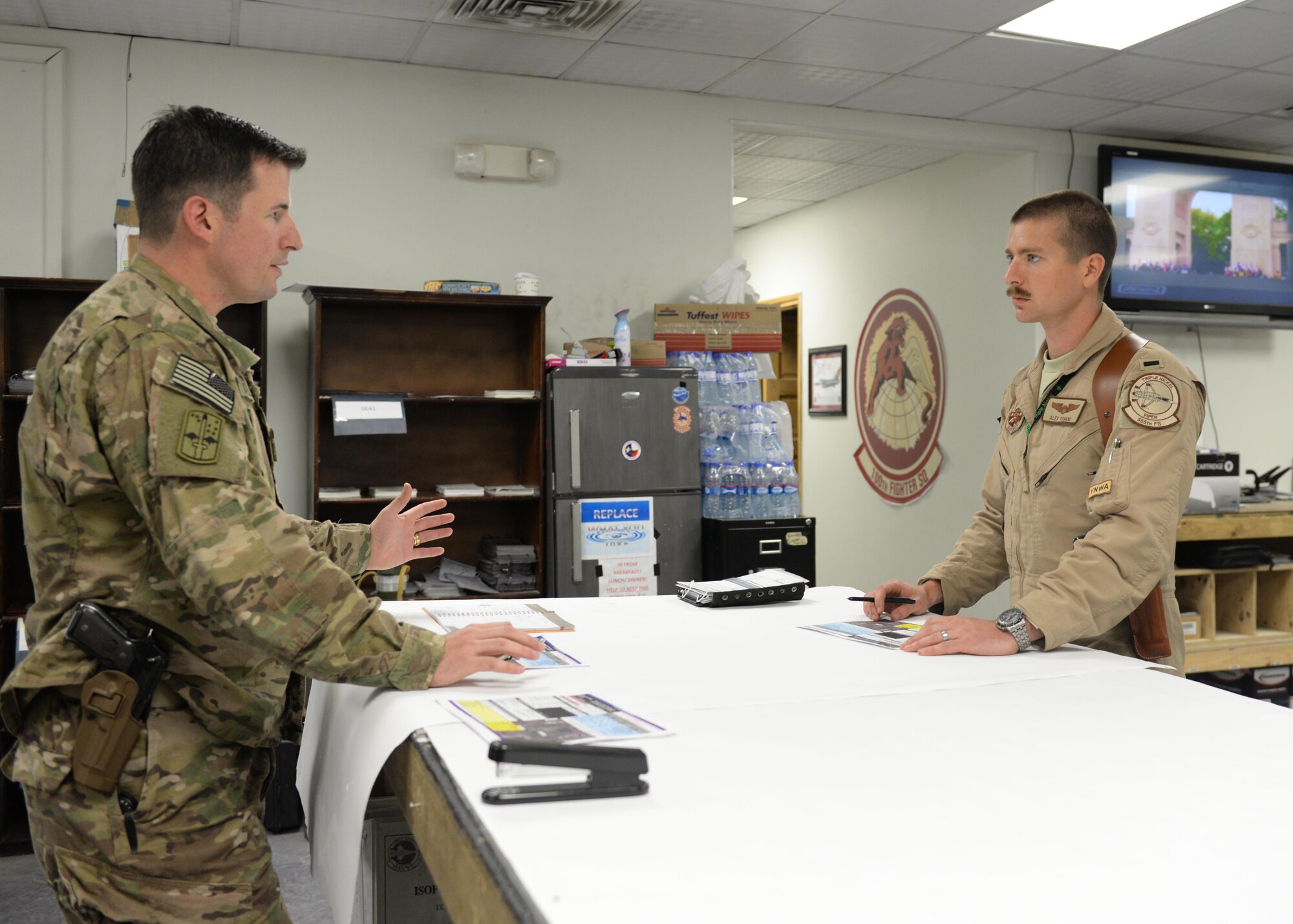 U.S. Army Capt Andrew Littel, 555th Expeditionary Fighter Squadron ground liaison officer, briefs Air Force 1st Lt. Alexander Tovani, 555th EFS F-16 fighter pilot, on a mission June 12, 2015, at Bagram Airfield, Afghanistan. As a GLO, Littel briefs pilots on mission parameters as well as provides pilots with a good perspective of what guys on the ground are going through. (U.S. Air Force photo by Senior Airman Cierra Presentado/Released)    
