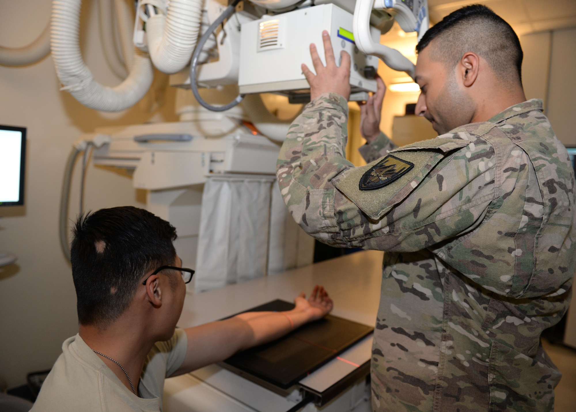 U.S. Air Force Staff Sgt. Asam Raja, 455th Medical Operations Squadron diagnostic imagery technician, provides x-ray support to a patient June 10, 2015, at Bagram Airfield, Afghanistan. Raja is responsible for providing diagnostics for patients in the emergency room, operating room, outpatient clinic and other clinics throughout the hospital. (U.S. Air Force photo by Senior Airman Cierra Presentado/Released)