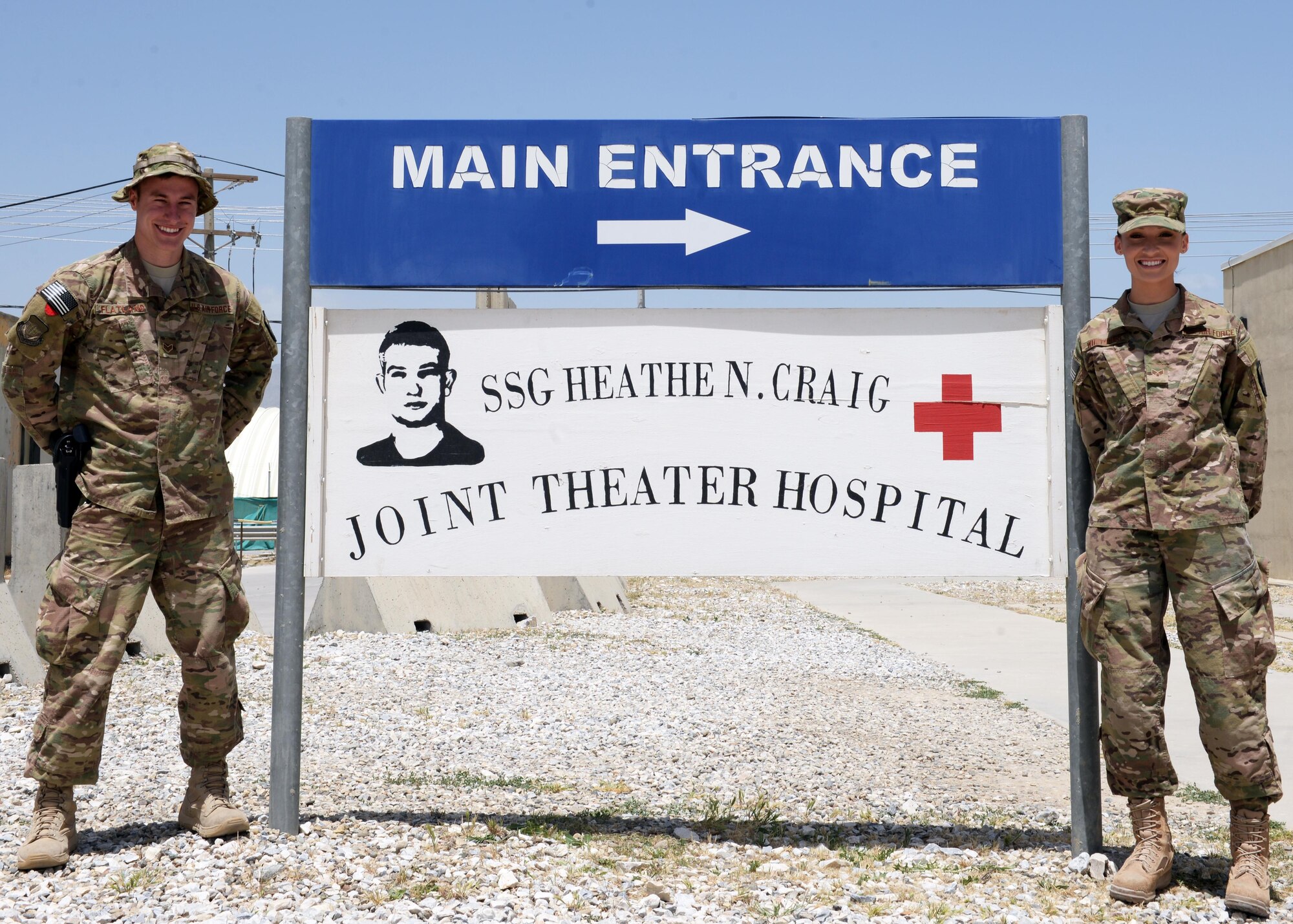 U.S. Air Force Senior Airmen Reese Flatland, left and Morrisa Whitcher, 455th Expeditionary Medical Group medical technicians, pose by the Craig Joint Theater Hospital May 9, 2015, at Bagram Airfield, Afghanistan. The Airmen are in charge of running the hospital’s volunteer program, which allows members to work in various clinics in the hospital throughout their deployment. (U.S. Air Force photo by Senior Airman Cierra Presentado/Released)