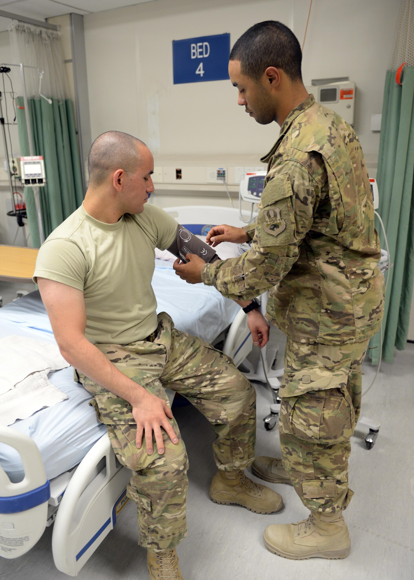 U.S. Air Force Airman 1st Class Torrey Jenkins, 455th Expeditionary Force Support Squadron PERSCO sustainment representative, takes the blood pressure from a patient while volunteering at the Craig Joint Theater Hospital June 10, 2015, at Bagram Airfield, Afghanistan. Jenkins is a member of the hospital volunteer program that allows military and civilians to help around different sections of the hospital throughout their deployment. (U.S. Air Force photo by Senior Airman Cierra Presentado/Released)