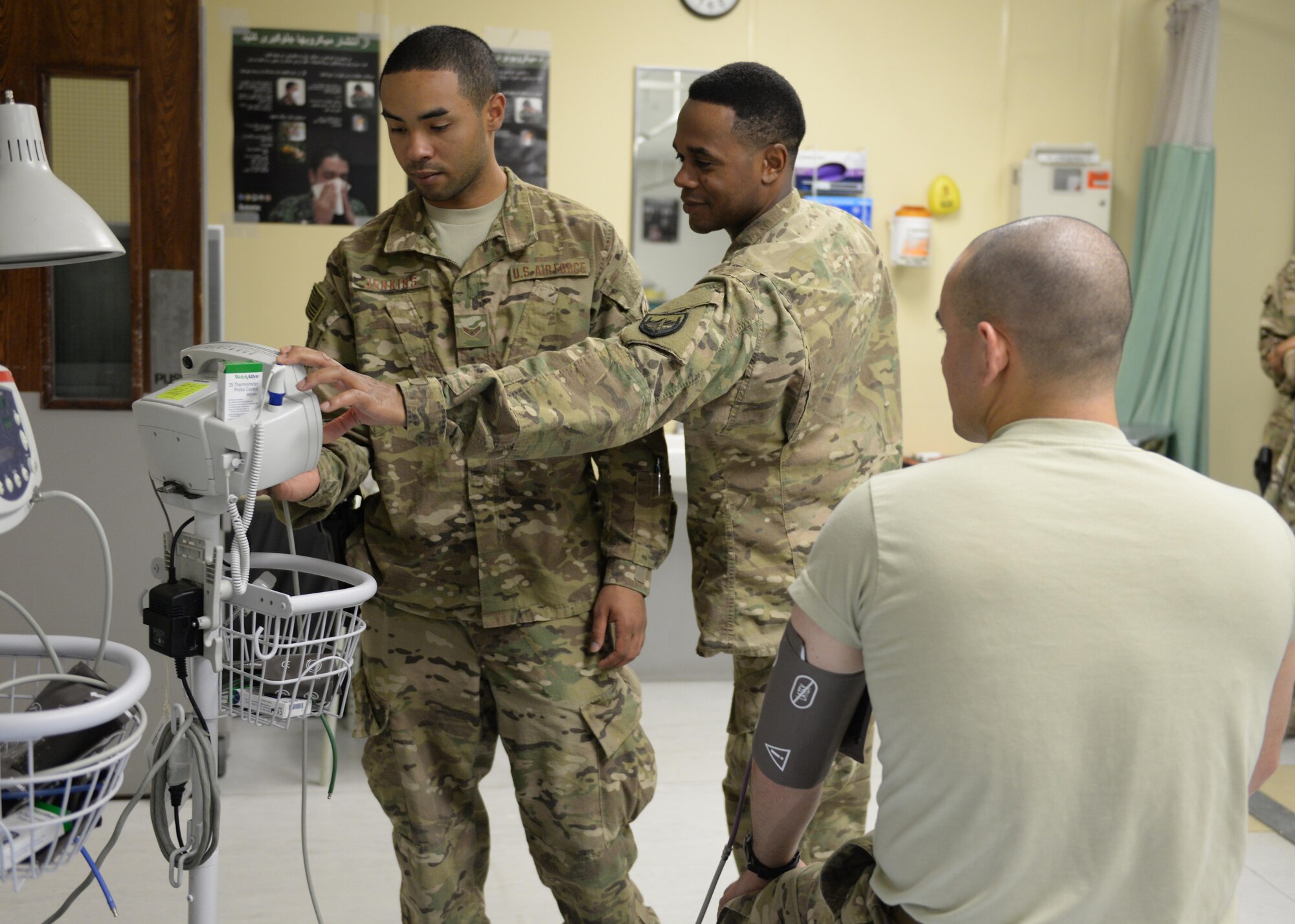 U.S. Air Force Airman 1st Class Torrey Jenkins, 455th Expeditionary Force Support Squadron PERSCO sustainment representative, gets assistance from a medical technician while volunteering at the Craig Joint Theatre Hospital June 10, 2015, at Bagram Airfield, Afghanistan. Jenkins is a member of the hospital volunteer program that allows military and civilians to help around different sections of the hospital throughout their deployment. (U.S. Air Force photo by Senior Airman Cierra Presentado/Released)
