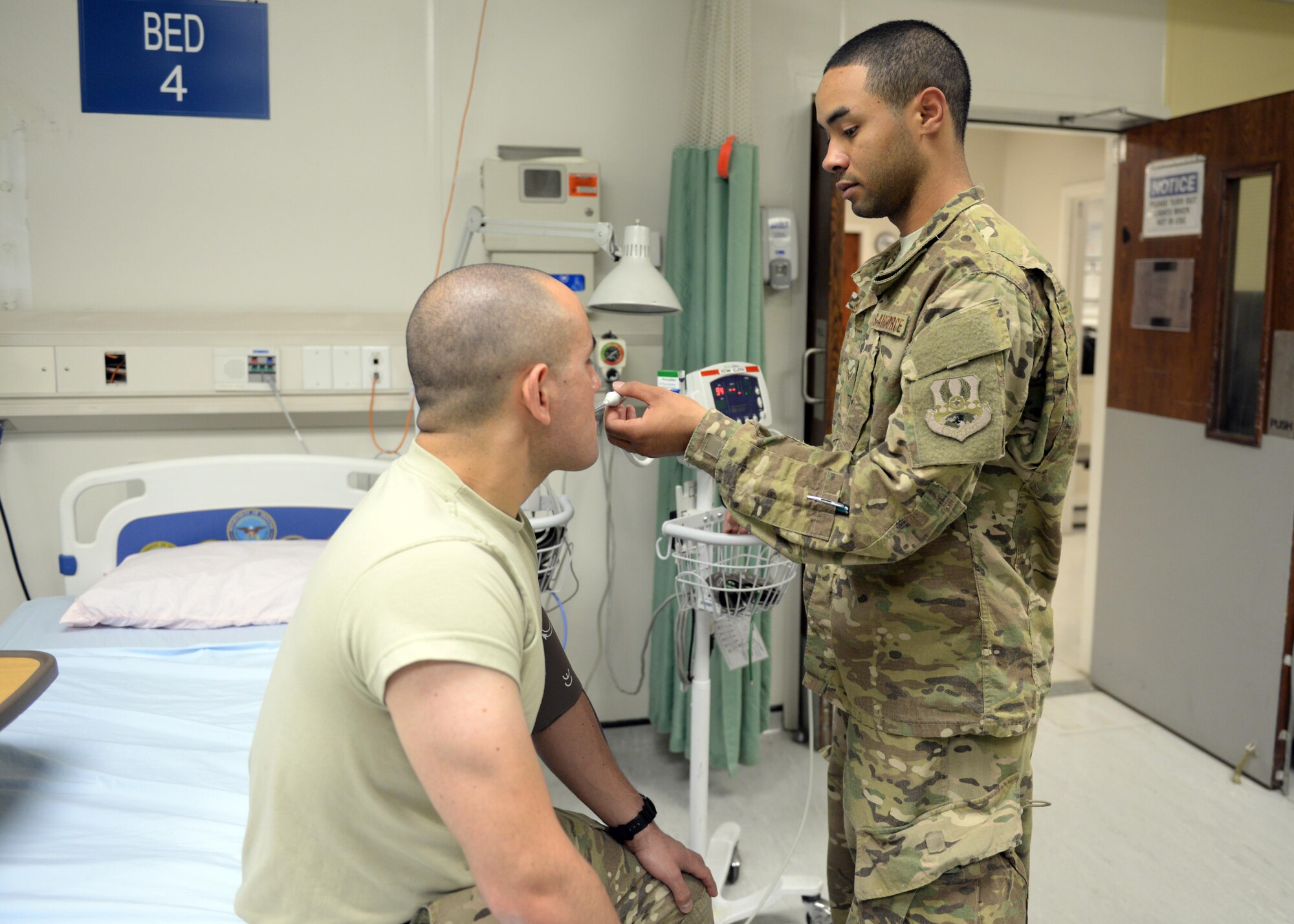 U.S. Air Force Airman 1st Class Torrey Jenkins, 455th Expeditionary Force Support Squadron PERSCO sustainment representative, take a patients temperature while volunteering at the Craig Joint Theater Hospital June 10, 2015, at Bagram Airfield, Afghanistan. Jenkins is a member of the hospital volunteer program that allows military and civilians to help around different sections of the hospital throughout their deployment. (U.S. Air Force photo by Senior Airman Cierra Presentado/Released)
