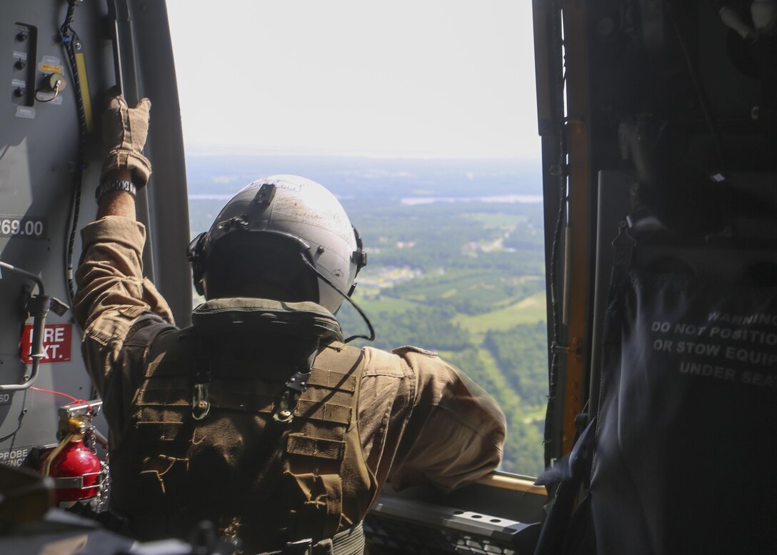 A crew chief with Marine Medium Tiltrotor Squadron 263 surveys the landscape while riding aboard an MV-22B Osprey, June 24, 2015. The VMM-263 flight crew transported Marines with Alpha Company, 1st Battalion, 8th Marine Regiment from the flight deck of the USS Whidbey Island to Camp Lejeune, N.C., where the company supported a battalion exercise. (U.S. Marine Corps photo by Cpl. Michelle Reif/Released)