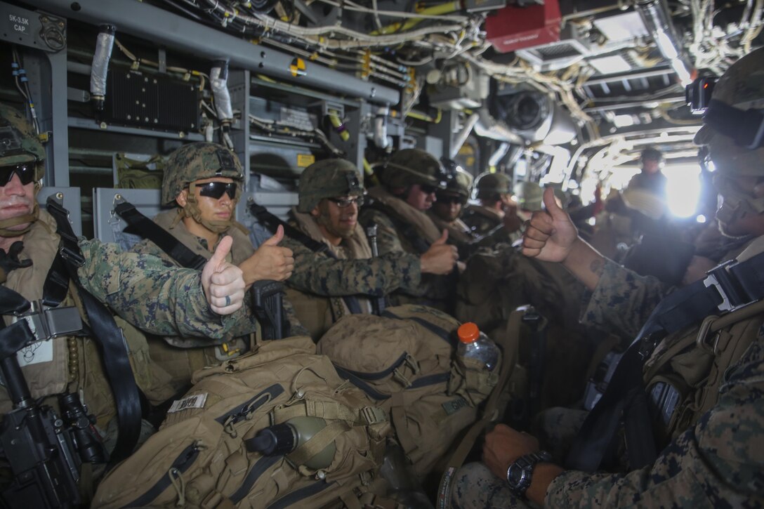 Marines with Alpha Company, 1st Battalion, 8th Marine Regiment signal they are ready for take-off aboard an MV-22B Osprey belonging to Marine Medium Tiltrotor Squadron 263, June 24, 2015. The VMM-263 flight crew transported Marines with Alpha Company from the flight deck of the USS Whidbey Island to Camp Lejeune, N.C., where the company supported a battalion exercise. (U.S. Marine Corps photo by Cpl. Michelle Reif/Released)