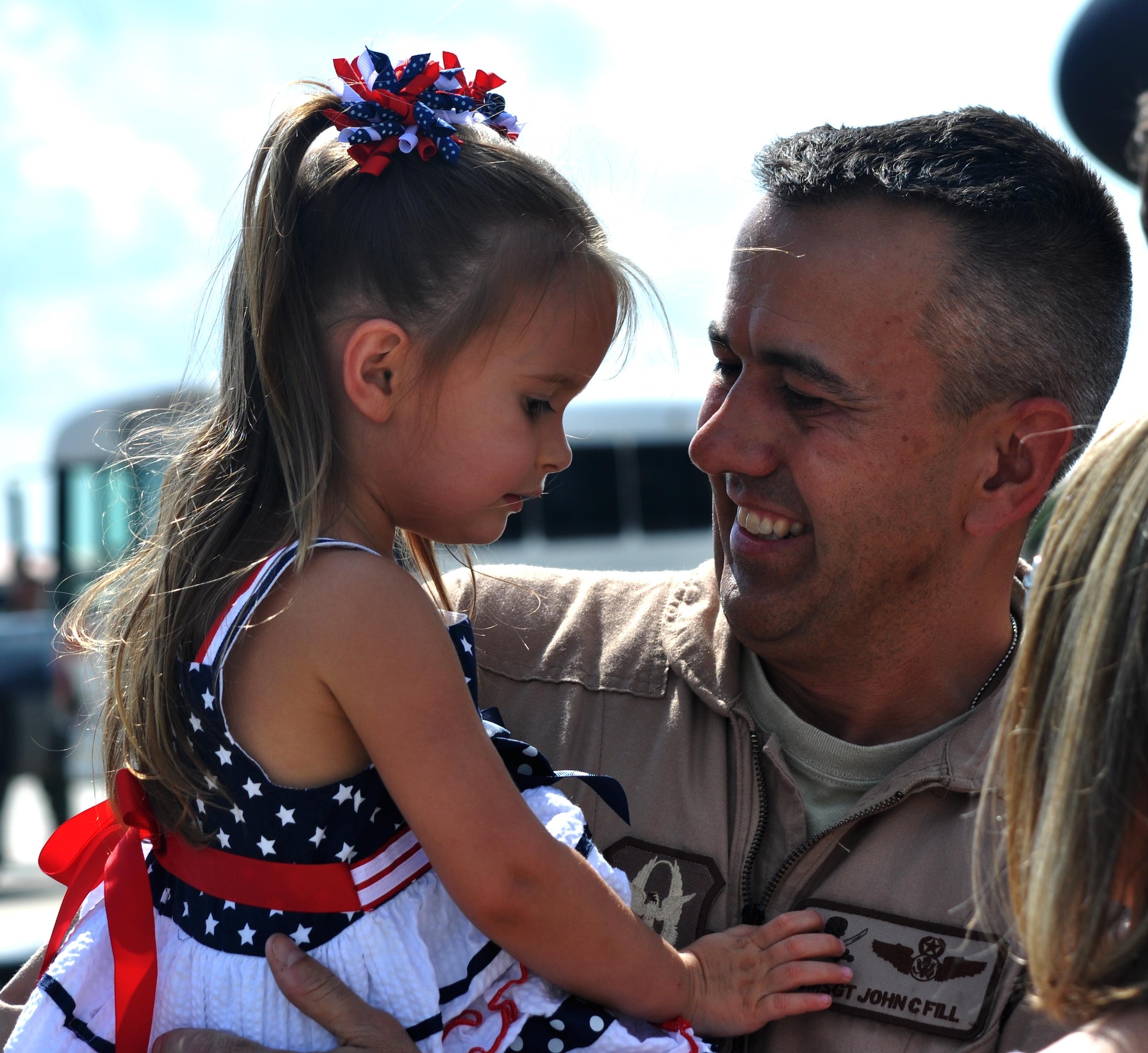 Chief Master Sgt. John Fill holds his daughter for the first time after returning from an extended deployment in southwest Asia on June 17, 2015 at MacDill Air Force Base. Fill is the Chief boom operator for the 63rd Air Refueling Squadron. Boom operators are responsible for extending the boom on a tanker to refuel other aircraft while in flight. (U.S. Air Force photo/Staff Sgt. Adam C. Borgman)