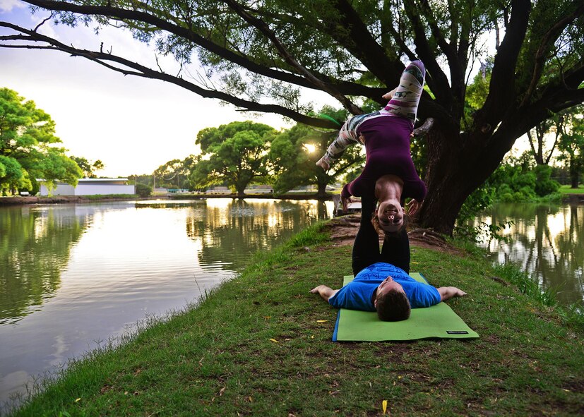 U.S. Air Force Capt. Rachel Schaefer, 27th Special Operations Wing assistant to the Director of Staff, balances solely on her husband’s feet during a self-taught acro-yoga pose June 14, 2015 at Hillcrest Park in Clovis, N.M. The pair has developed a newfound sense of trust as they have learned to test their physical limits. (U.S. Air Force photo/Senior Airman Chip Slack) 