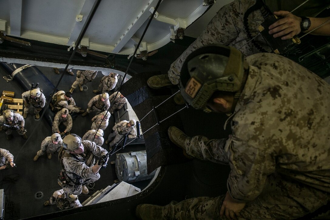 ARABIAN SEA (June 23, 2015) U.S. Marines with the 15th Marine Expeditionary Unit’s Maritime Raid Force practice climbing caving ladders aboard the USS Essex (LHD 2). This skill is important for the Marines, who may need to climb onto a ship or hovering aircraft during training or operations. The 15th MEU is embarked on the Essex Amphibious Ready Group and deployed to maintain regional security in the U.S. 5th Fleet area of operations. (U.S. Marine Corps photo by Cpl. Anna Albrecht/ Released)