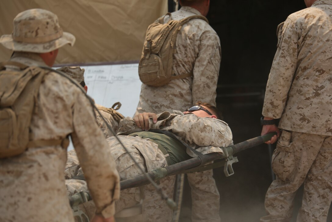 Marines with 4th Medical Battalion, 4th Marine Logistics Group, Marine Forces Reserve, carry a casualty in a mass heat casualty exercise during the 4-15 Integrated Training Exercise aboard Marine Corps Air Ground Combat Center, Calif., June 20, 2015. During the mass heat casualty exercise, Marines and sailors faced a situation where multiple casualties were rapidly brought into the medical station, and Marines and Sailors had to work together efficiently to ensure that all casualties were assessed and treated properly. (U.S. Marines Corps photo by Cpl. Ian Ferro)