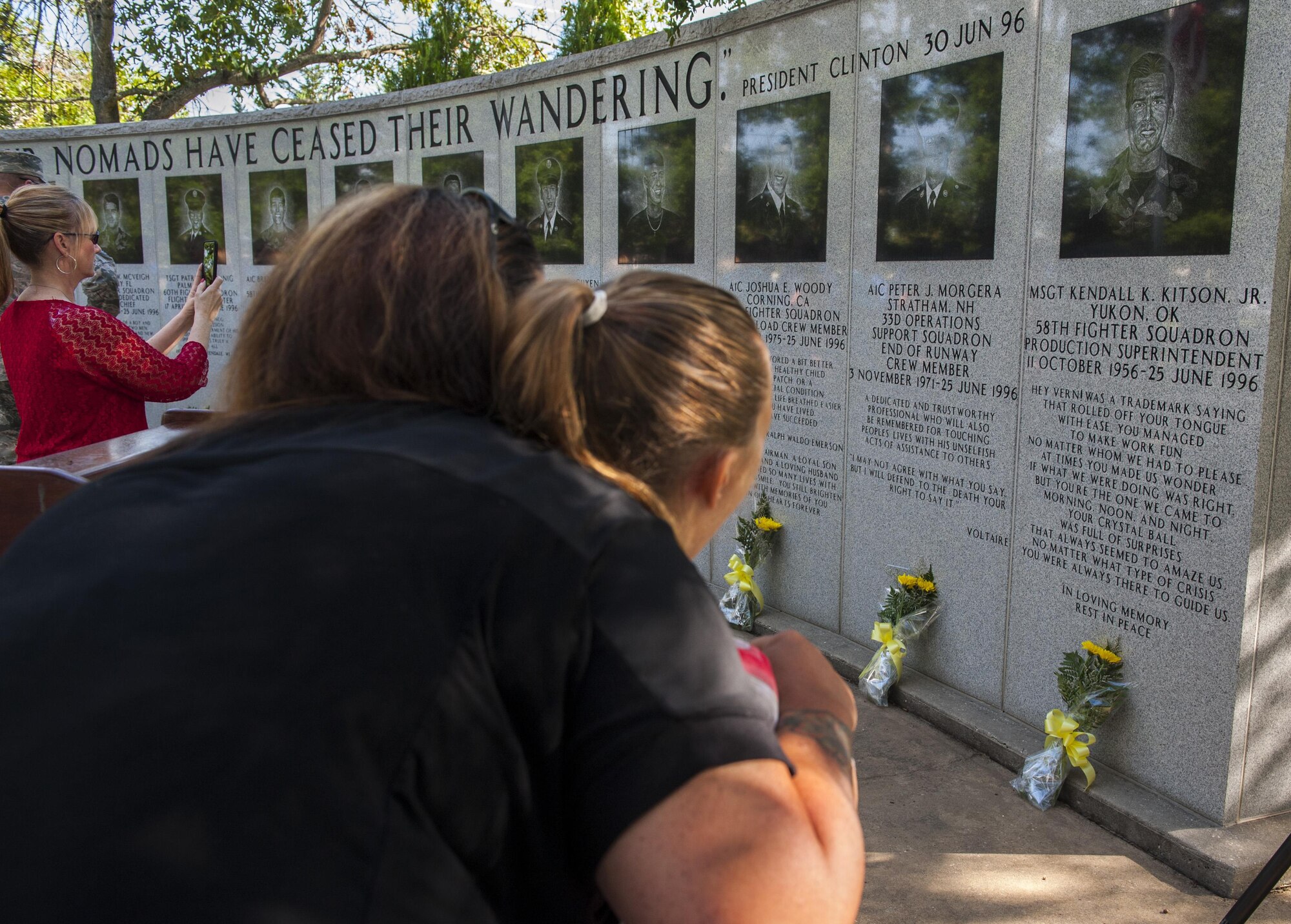 Tracy Bozeman, former 58th Fighter Squadron supply personnel, tells her daughter, Carly, stories about Master Sgt. Kendall Kitson, Jr., 58th FS production superintendent and fallen Nomad, after the 19th anniversary Khobar Tower memorial ceremony, June 25, 2015, on Eglin Air Force Base, Florida. Bozeman, a Nomad for 10 years, spoke highly of Kitson, a flight line supervisor during the deployment, and how he was the best and most patient supervisor she had ever worked with in the Air Force. (U.S. Air Force photo/Staff Sgt. Marleah Robertson)