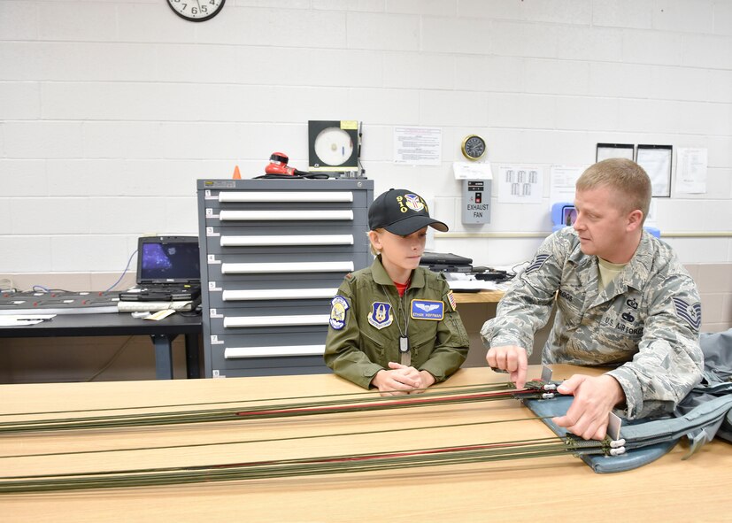 Tech Sgt. Ed Peggs, an aircrew flight equipment craftsman with the 910th Airlift Wing, shows honorary 2nd Lt. Ethan Hoffman how a parachute works here, June 24, 2015. Twelve-year-old Ethan was sworn in as an honorary second lieutenant as he became the 910th Airlift Wing’s 62nd Pilot for a Day, receiving a day of military experiences and mementos. Ethan was selected for the program by Akron Children’s Hospital in Boardman where he is treated for Bartter Syndrome, a rare kidney disease he has had since birth. (U.S. Air Force photo/Eric M. White)