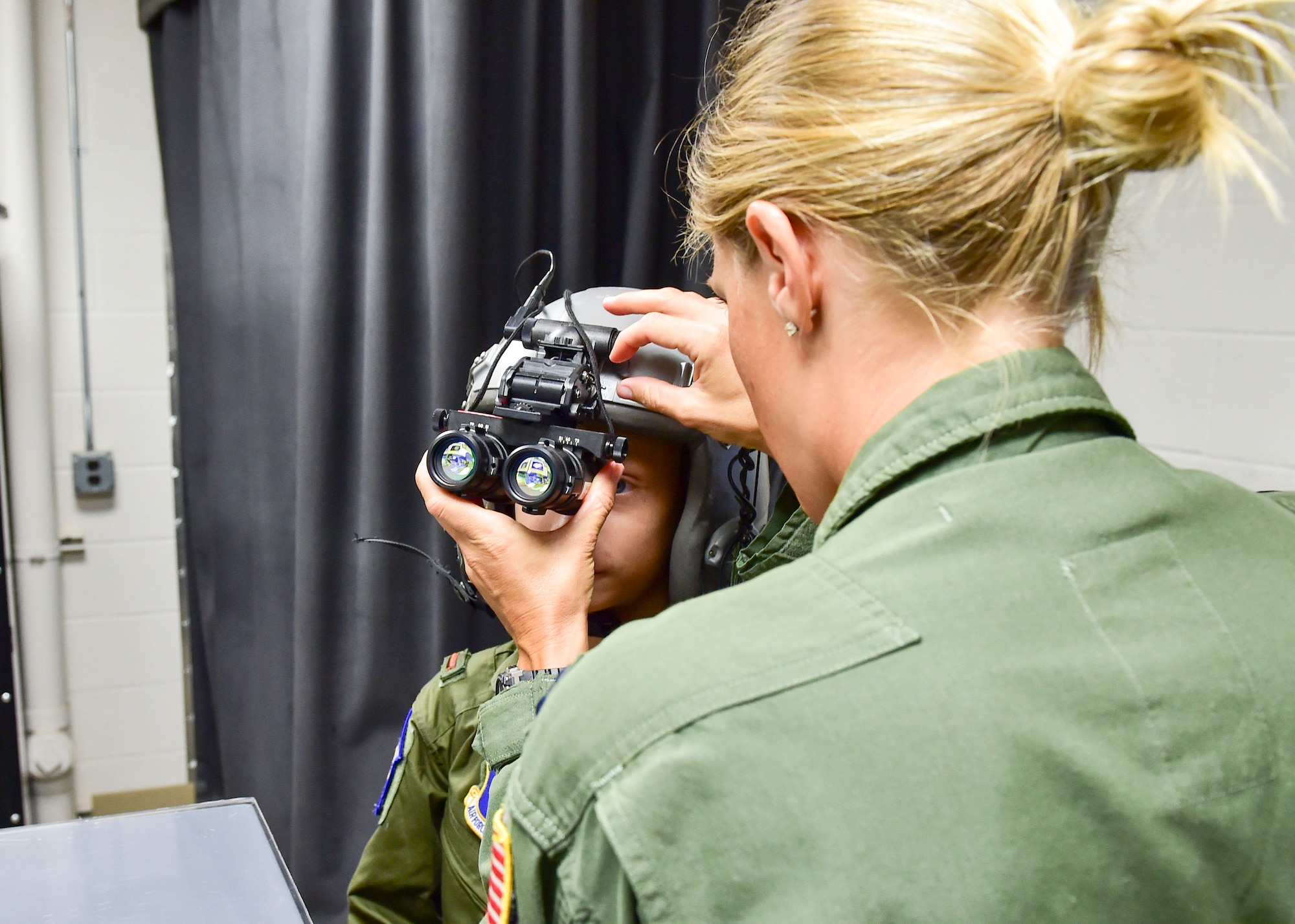 Capt. Shannon Baker, a navigator with the 757th Airlift Squadron here, helps Ethan Hoffman adjust night vision goggles here, June 24, 2015. Twelve-year-old Ethan was sworn in as an honorary second lieutenant as he became the 910th Airlift Wing’s 62nd Pilot for a Day, receiving a day of military experiences and mementos. Ethan was selected for the program by Akron Children’s Hospital in Boardman where he is treated for Bartter Syndrome, a rare kidney disease he has had since birth. Baker was his official escort for the day. (U.S. Air Force photo/Eric M. White)