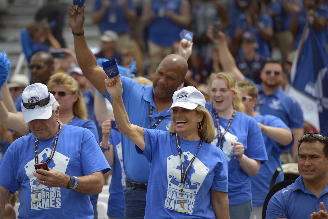 Family members cheer as members of service teams proceed on field during the opening ceremony of the 2015 Department of Defense Warrior Games at the National Museum of the Marine Corps in Quantico, Va., June 19, 2015. The Warrior Games features athletes from throughout the Defense Department who compete in Paralympic-style events for their respective military branches.  (Department of Defense photo/Glenn Fawcett)