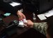 Natalie Sundquist, 1st Special Operations Wing military personnel services human resource assistant, hands a customer a common access card, June 25, 2015, at Hurlburt Field, Fla. Hurlburt Field Military Personnel Section serves more than 8,500 active duty members, 32,000 retirees, 1,200 civilian employees and their family members. (U.S. Air Force photo by Airman 1st Class Ryan Conroy/Released)