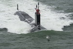 150521-O-ZZ999-110 ATLANTIC OCEAN (May 21, 2015) A dolphin jumps in front of the Virginia-class attack submarine Pre-Commissioning Unit (PCU) John Warner (SSN 785) as the boat conducts sea trials in the Atlantic Ocean. (U.S. Navy photo courtesy of Huntington Ingalls Industries by Chris Oxley/Released)
