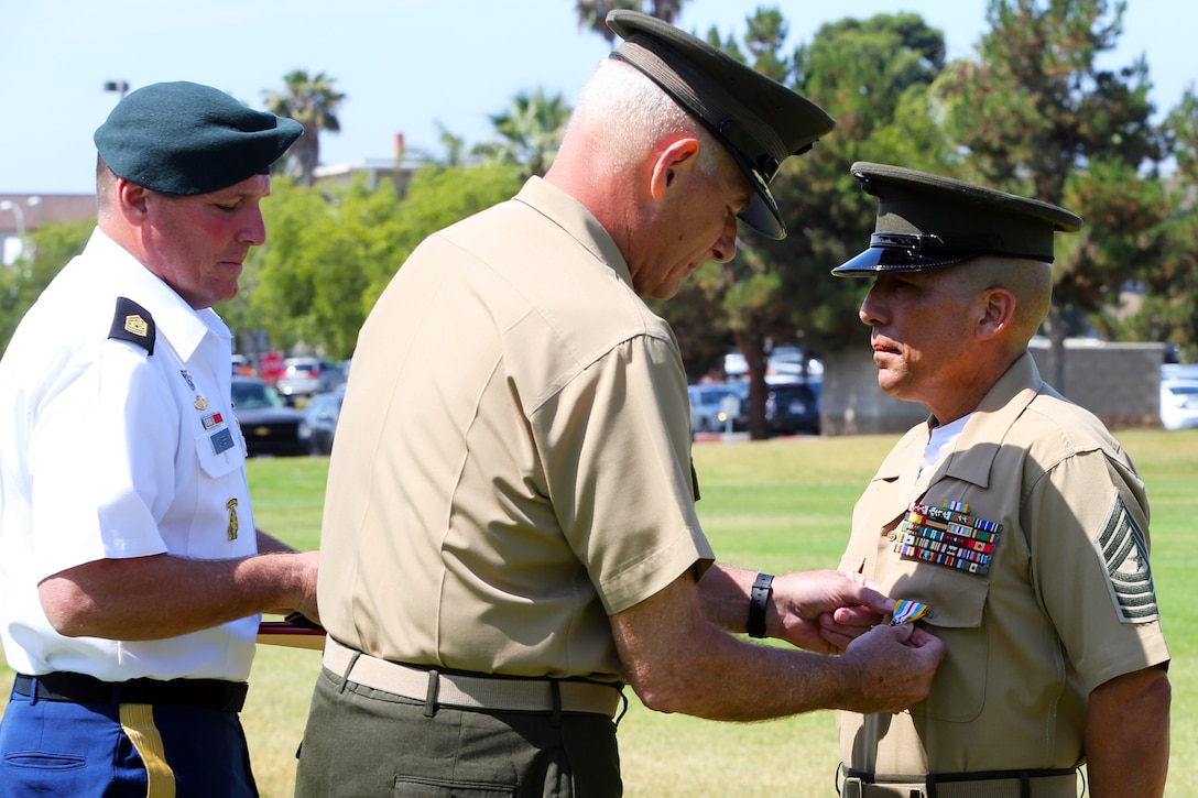 Gen. John F. Kelly, center, and Command Sgt. Maj. William B. Zaiser, left, presented Sgt. Maj. Juan M. Hidalgo Jr. with the Defense Superior Service Medal during Hidalgo’s retirement ceremony at the 11 Area Parade Field, June 26. The Defense Superior Service Medal is a senior American military decoration of the Department of Defense, awarded to members of the United States Armed Forces who perform superior meritorious service in a position of significant responsibility. Kelly is the commander of the U.S. Southern Command and Zaiser is the command senior enlisted advisor to U.S. Southern Command. (Photo by Lance Cpl. Asia J. Sorenson/Released)