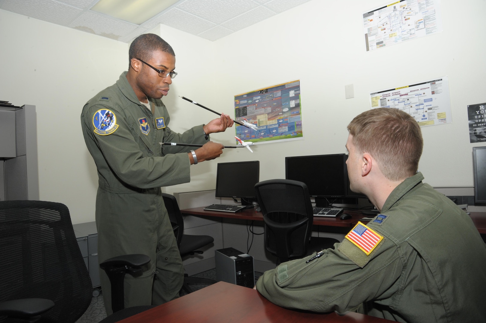 1st Lt. Chris Tobiere (left), a T-1 Jayhawk instructor pilot assigned to the 86th Flying Training Squadron at Laughlin AFB, Texas, discusses in-flight safety procedures with Capt. Mark Thompson, 99th Flying Training Squadron safety officer, during the “FAIP-a-Palooza” conference June 26, 2015 at Joint Base San Antonio-Randolph, Texas.  The conference was hosted by the 12th Flying Training Wing to provide First Assignment Instructor Pilots (FAIP) across Air Education and Training Command officer professional development information and stimulate cross-talk amongst FAIP’s. (U.S. Air Force photo/Joel Martinez)