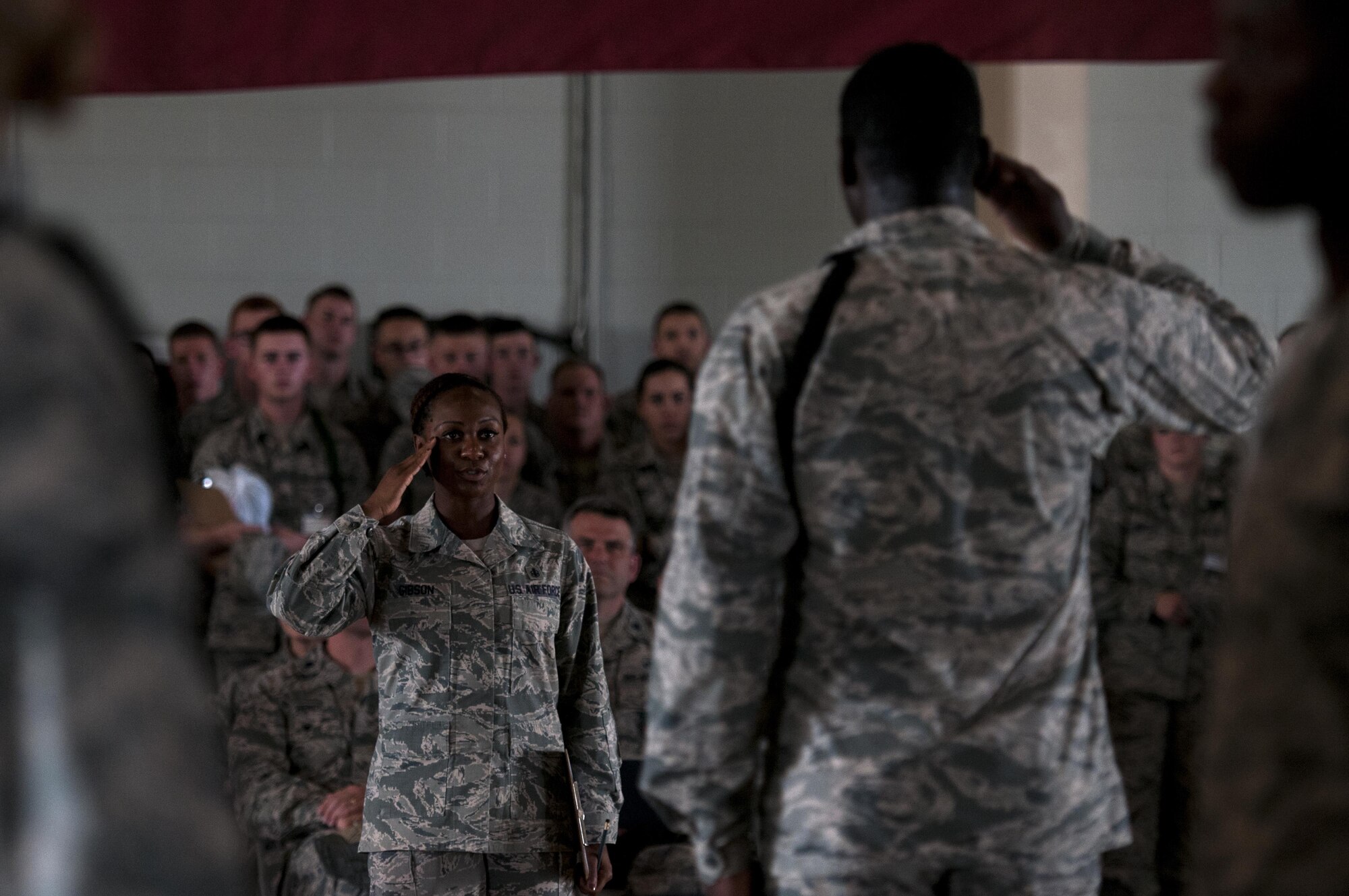 U.S. Air Force Tech. Sgt Curtrell L. Gibson, 17th Training Wing Airman Leadership School instructor, salutes a drill lead from the 316th Training Squadron signifying the end of the regulation drill circuit inside the High Bay at the Louis F. Garland Fire Academy on Goodfellow Air Force Base, Texas, June 22, 2015. The 316th TRS drill team won both the regulation drill and the exhibition drill circuits. (U.S. Air Force photo by Senior Airman Scott Jackson/Released)

