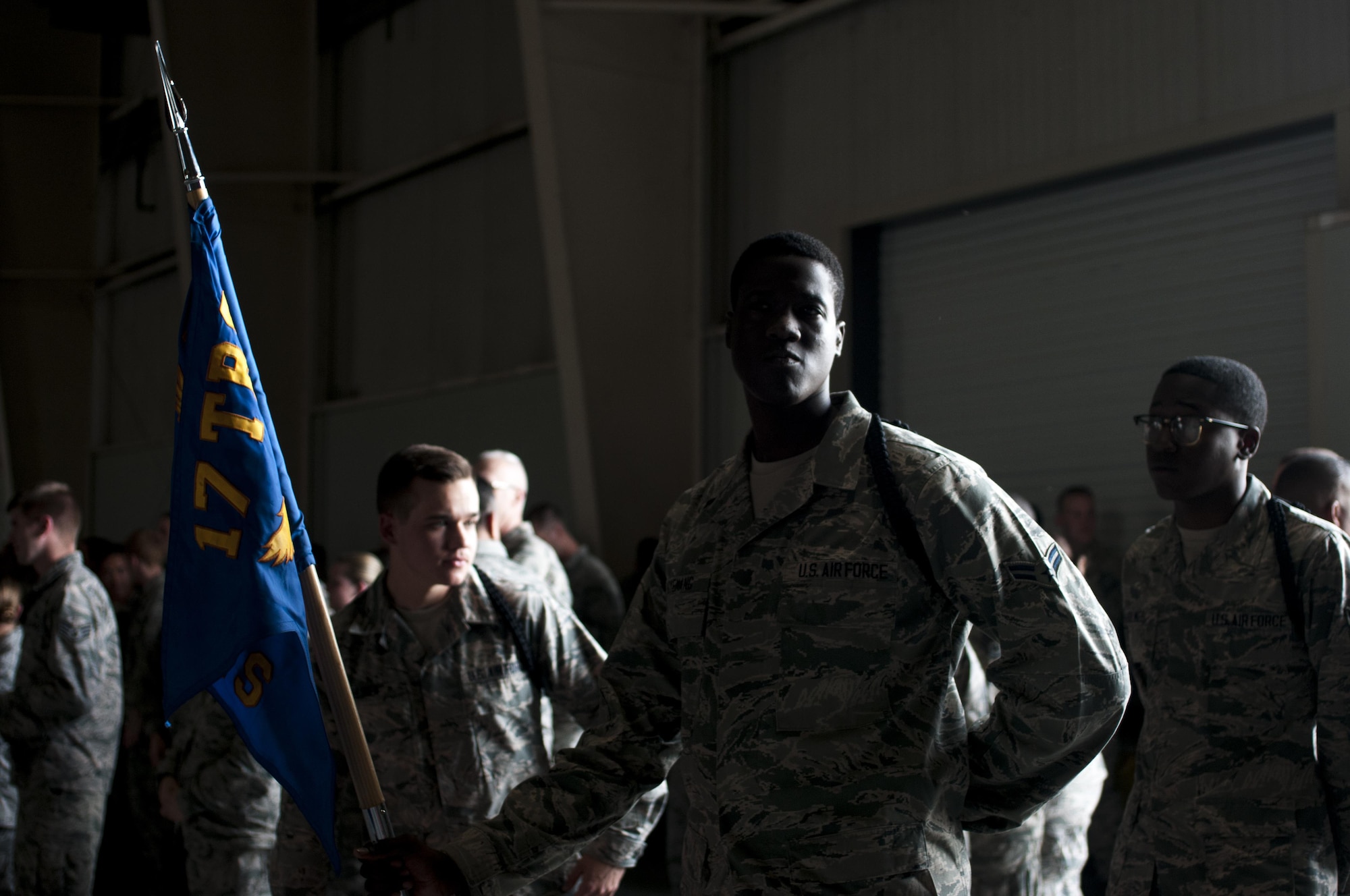 U.S. Air Force Airman 1st Class Brandon O. Agyemang, 316th Training Squadron student, stands with the guide-on awaiting the start of the drill competition in the High Bay at the Louis F. Garland Fire Academy on Goodfellow Air Force Base, Texas, June 22, 2015. The drill competition featured three teams competing against each other in two events. (U.S. Air Force photo by Senior Airman Scott Jackson/Released)