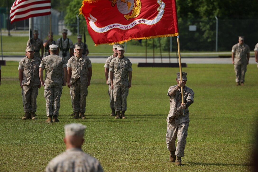 Sergeant Maj. Felix W. Acosta, Marine Raider Regiment sergeant major, delivers the colors during the MRR change of command ceremony at the MARSOC headquarters at Stone Bay, aboard Marine Corps Base Camp Lejeune, N.C., June 26, 2015.