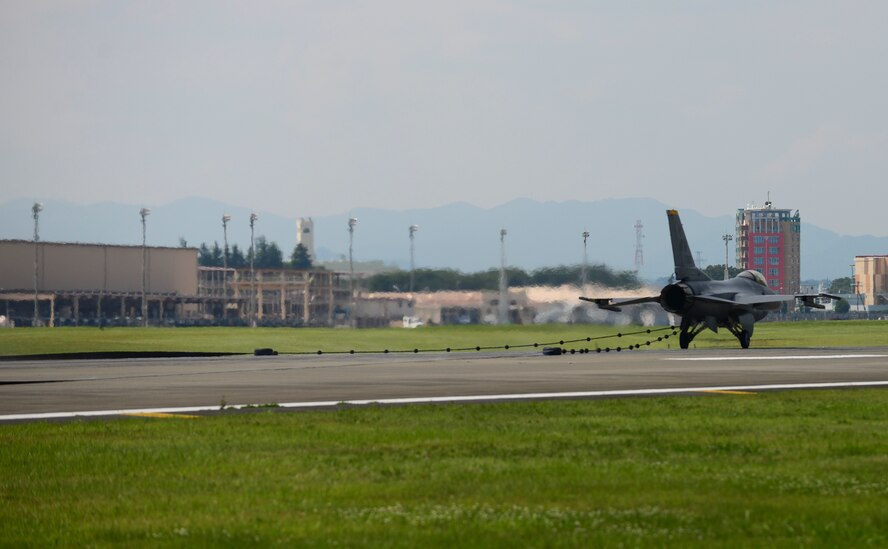 A U.S. Air Force F-16 Fighting Falcon from Misawa Air Base, Japan, connects its J-Hook to an aircraft arresting system at Yokota Air Base, Japan, June 24, 2015. As a pilot lands on a runway during an in-flight emergency, the pilot will drop the J-Hook to the 1.25 inch steel cable of the AAS to assist the jet in rapidly decreasing its speed. (U.S. Air Force photo by Senior Airman David Owsianka/Released)